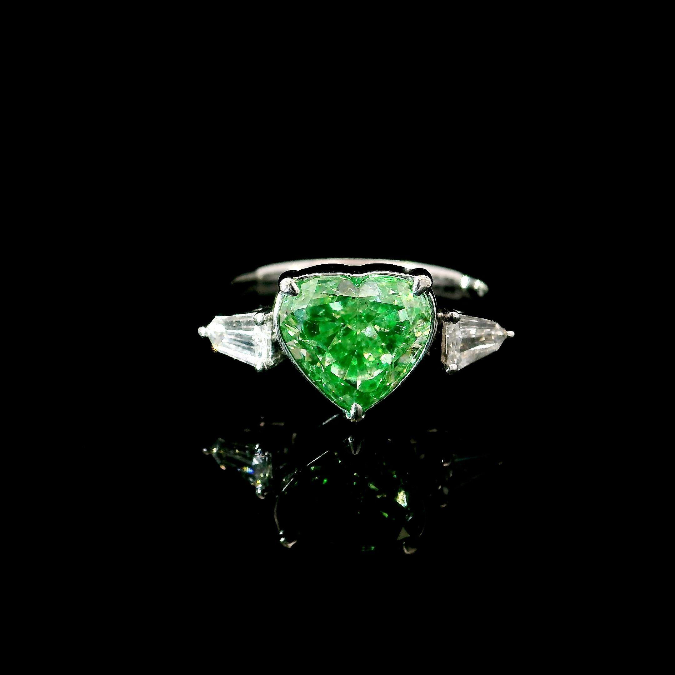 18kt white gold ring with diamonds
  
  Gold colour & karat: White gold 18kt
  Weight: 5.097 grams
  
  Set with-
  Stone type: Diamonds
  Shape: Heart
  Carat: 3.00 ct
  Colour: Fancy Green
  Clarity: SI
  
  Surrounding Stones: Diamonds
 1) White