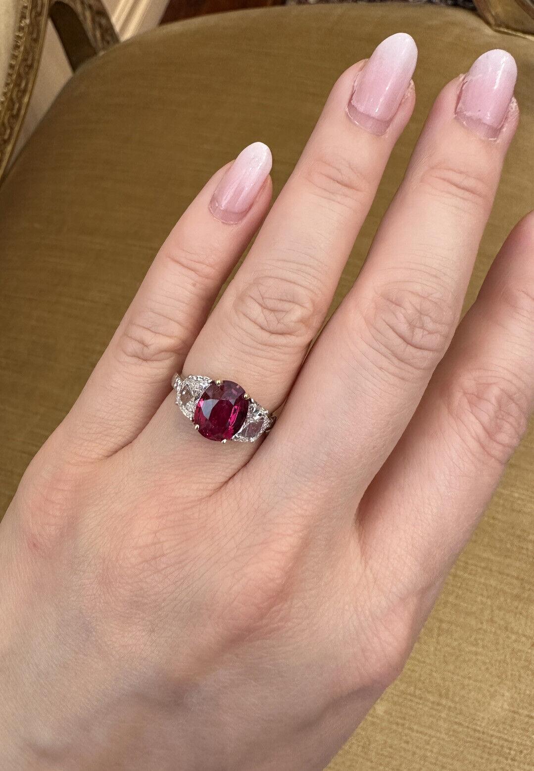 AGL CERTIFIED UNHEATED 3.03 carat Oval Ruby Three-Stone Ring in Platinum

Oval Ruby Three-Stone Ring features an Oval Mixed cut Red Ruby accented by Two Half Moon cut Diamonds set in Platinum. The ruby originates from Mozambique and is