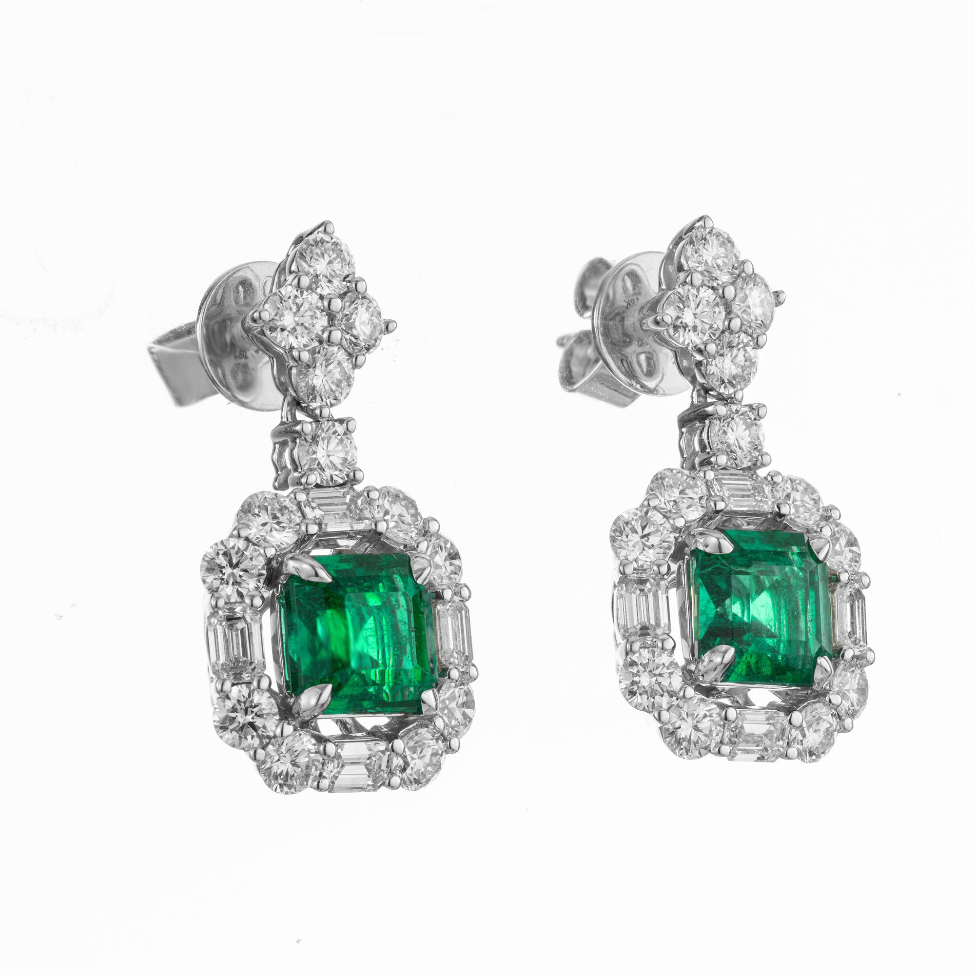 Sensational emerald and diamond dangle earrings. 2 octagonal emeralds one at 1.66cts and the other at 1.47cts mounted in 18k white gold. Each emerald has a halo of alternating round and emerald cut diamonds. Both upper dangles are adorned with 5