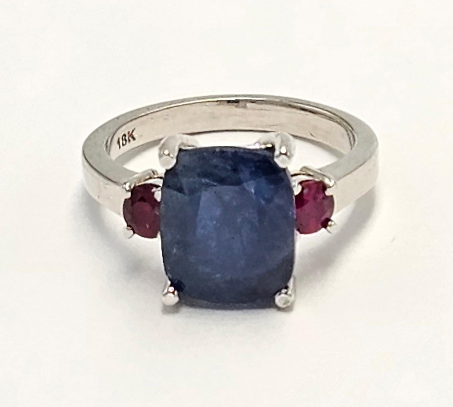 Set in a custom designed 18K white Gold ring, surrounded by beautiful and carefully curated pair of Burmese Rubies, this gorgeous AGL certified cushion shaped Natural Burmese Sapphire weighing 3.75 carats has a unique and rare combination of being