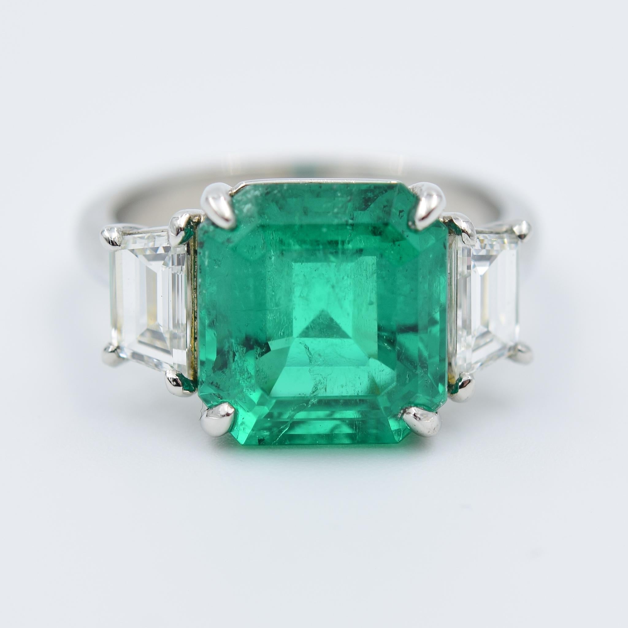 This ring hosts a 4.64 carat Columbian Emerald with a fascinating emerald cut styling.  The emerald has an AGL report which is pictured in the photos for further details on the characteristics.  The mounting wonderfully compliments the gemstone with
