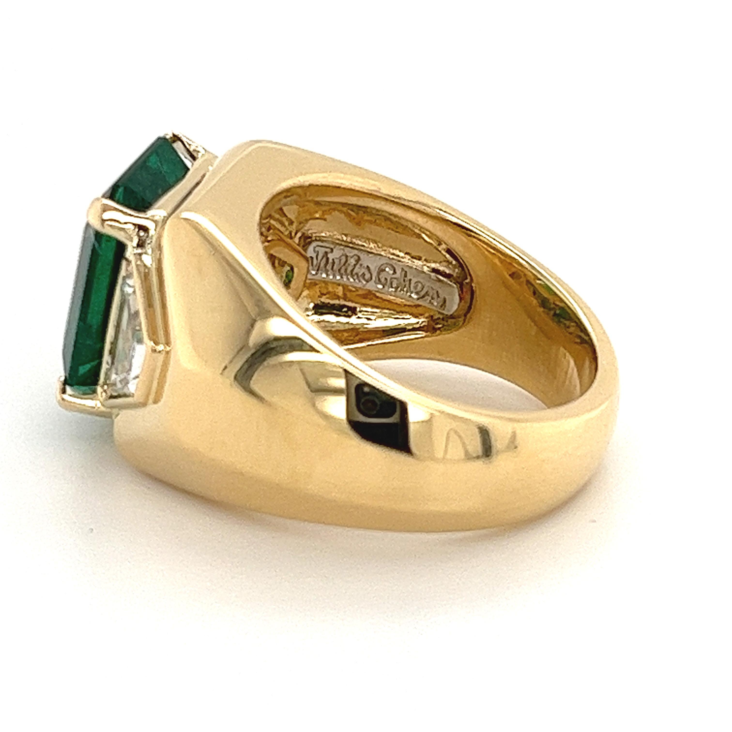 Introducing this Julius Cohen signed ring with a minor oil Zambian Emerald and 1 carat total in trapezoid cut diamond side stones set in an 18k yellow gold ring. AGL certified with treatment and origin report. 

This 5.40-carat vibrant emerald bears