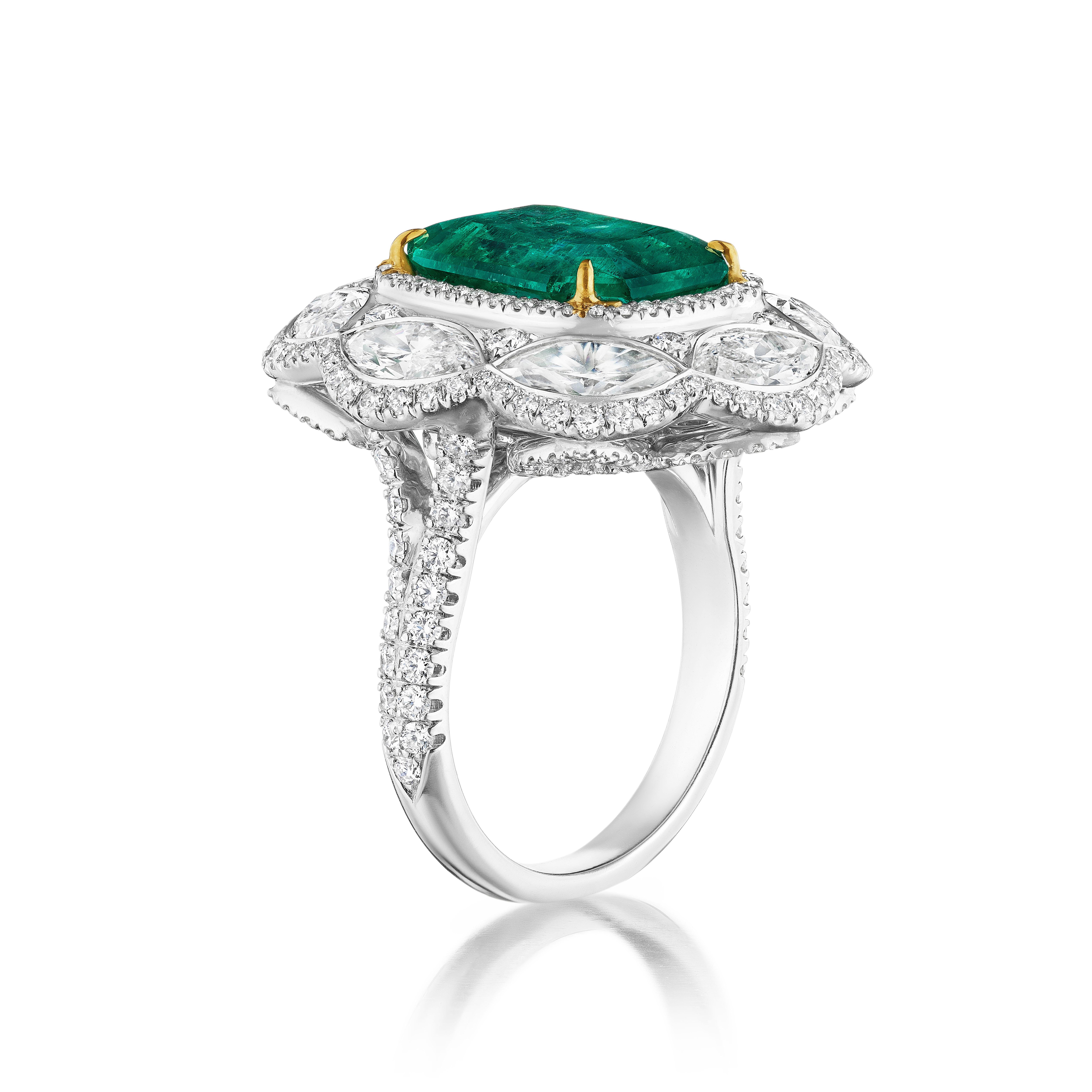 Im Mittelpunkt steht ein wunderschöner Smaragd von 6,16 Karat im Smaragdschliff mit lebhafter grüner Farbe, ausgezeichnetem Schliff und Form. Umgeben von Marquise und runden Diamanten. Gefasst in Platin mit 18 Karat Gelbgold Zacken auf dem