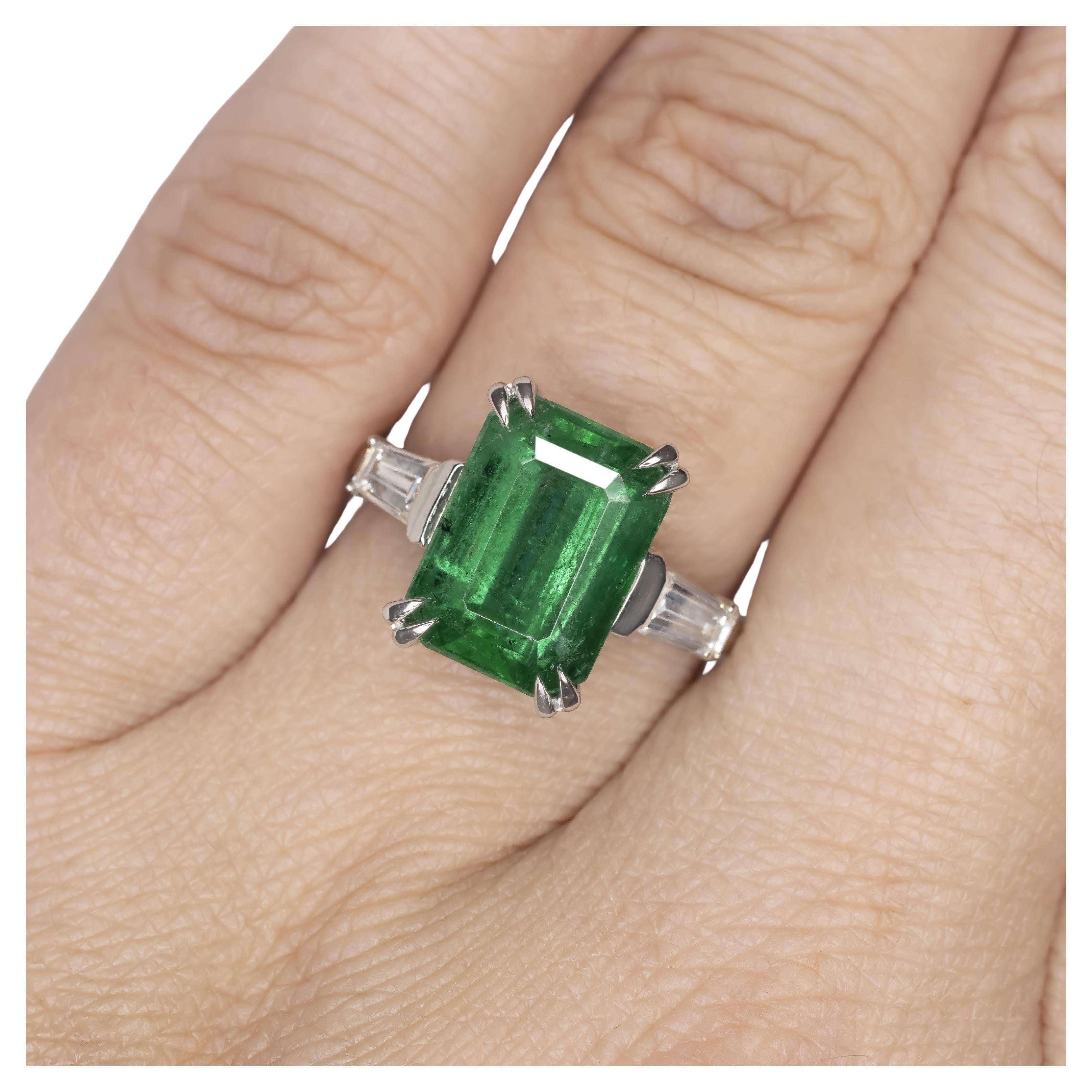 Platinum 6.47 Carat Natural Emerald and Diamond Ring with Tapered Baguettes

This exquisite ring showcases a captivating 6.47-carat natural emerald, certified by AGL as originating from Zambia. The emerald, with its vibrant green hue and impressive