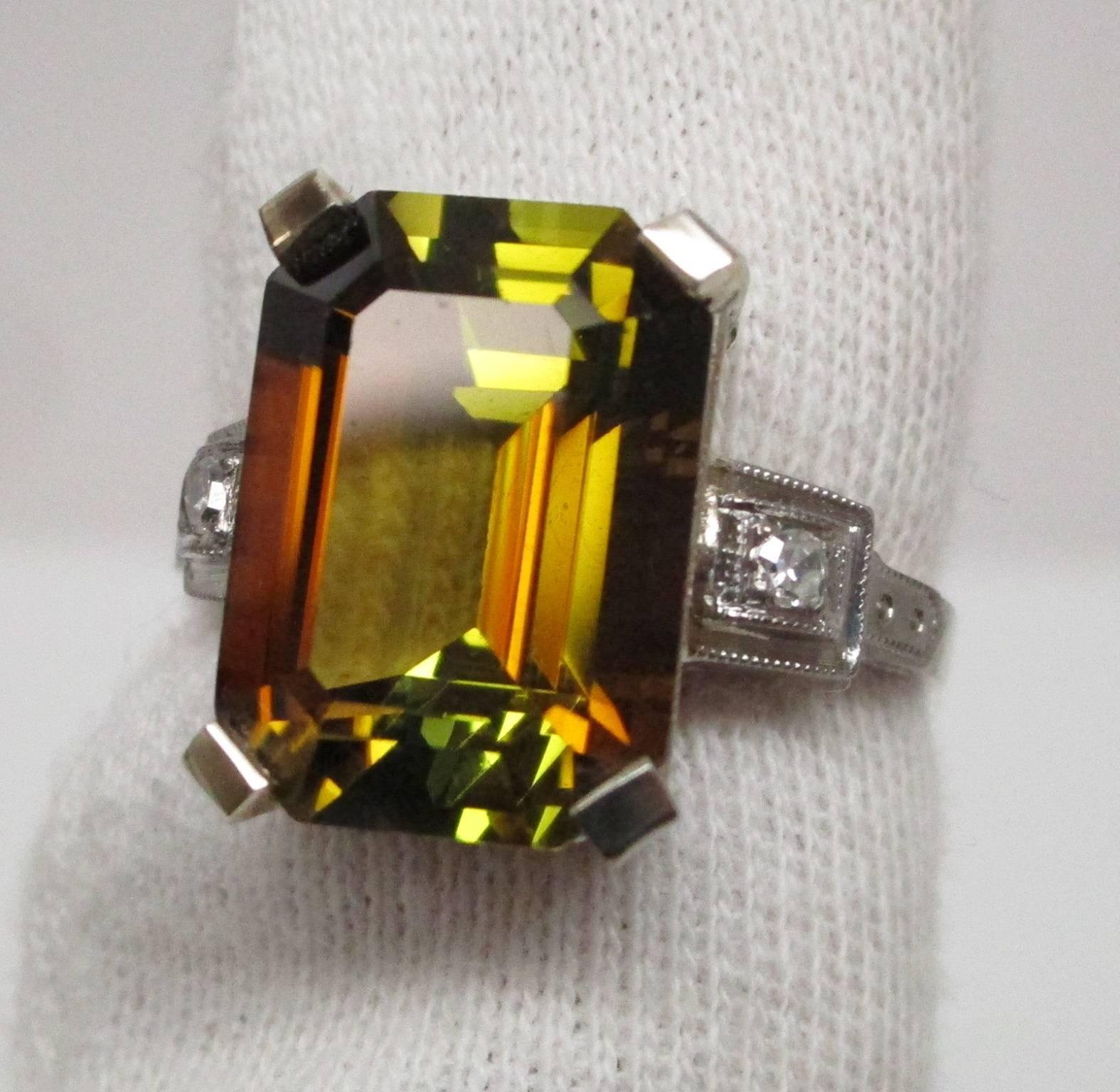 This is the most amazing ring you will ever see! The center stone is a 6.94 carat, massive, emerald cut Orange Tourmaline, an extremely rare stone indeed. It has been certified by the American Gem Lab, AGL, as a natural, untreated, as it came out of