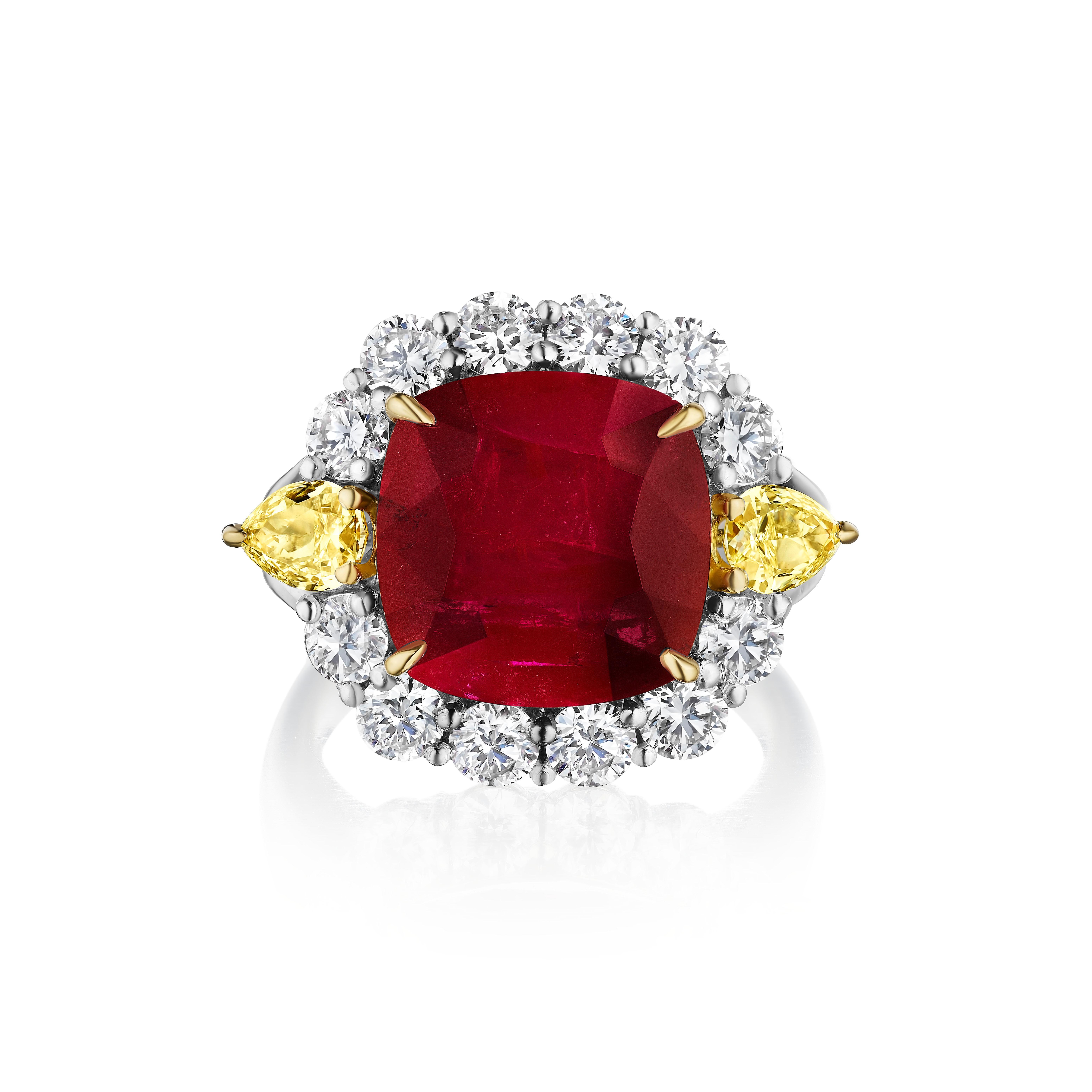 Centered upon a 7.32 Carat Cushion shaped Ruby, accompanied by AGL certificate stating it is heated. 

Flanked by Pear shaped Yellow Diamonds weighing 0.80 Carats. 
Surrounded by 12 Round Diamonds weighing 1.35 Carats

Set in Platinum and 18 Karat