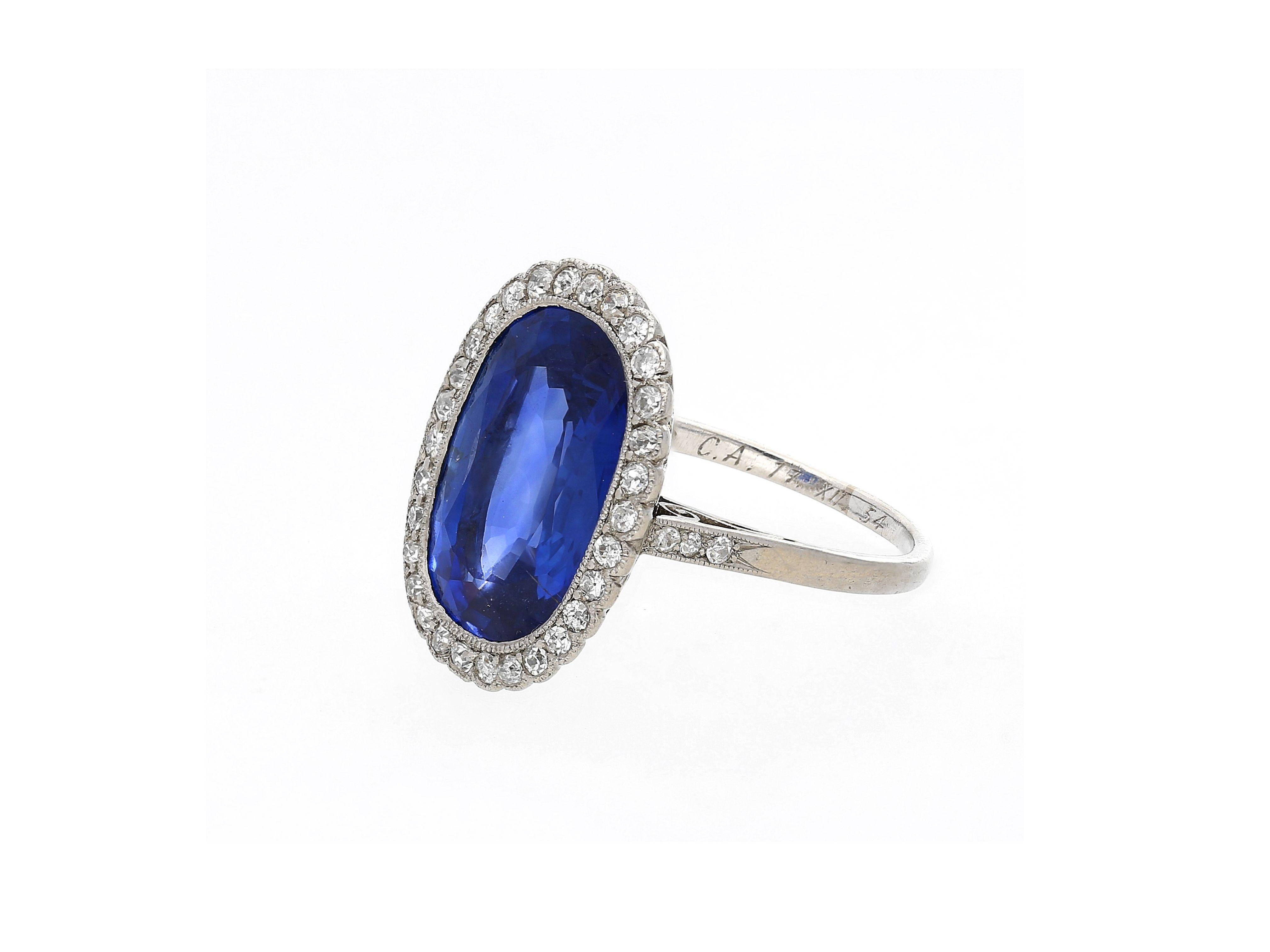 AGL Certified 7.76 Carat natural Burma Cushion Cut Blue Sapphire Ring in Platinum. Originating from the legendary Edwardian-Art Deco era. Circa 1915-1935. 

This vintage ring features a stunning hand made filigree on the bottom of the ring basket