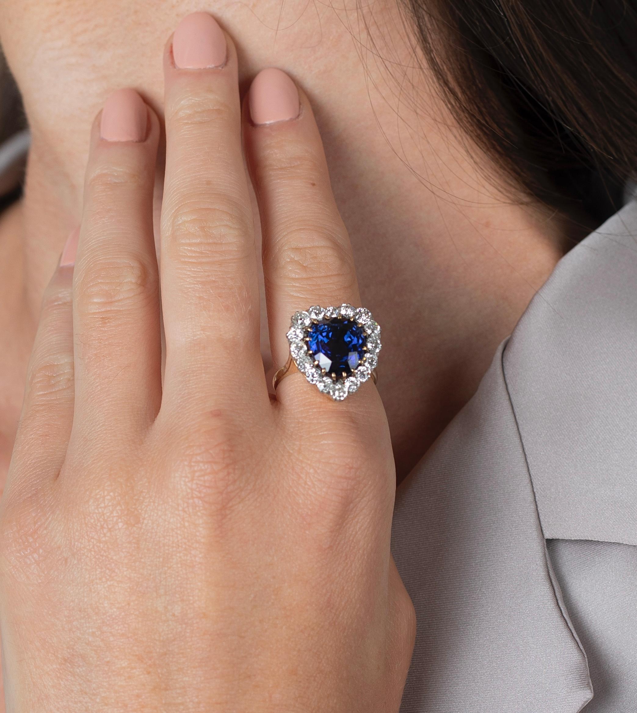 9 Carat no heat Blue Sapphire of Ceylon origin adorned with a 16 round-shaped, old European cut diamond halo. Stones set in a secure multi-prong setting with a carved basket mounting. A true vintage masterpiece.

The Blue Sapphire center stone is a
