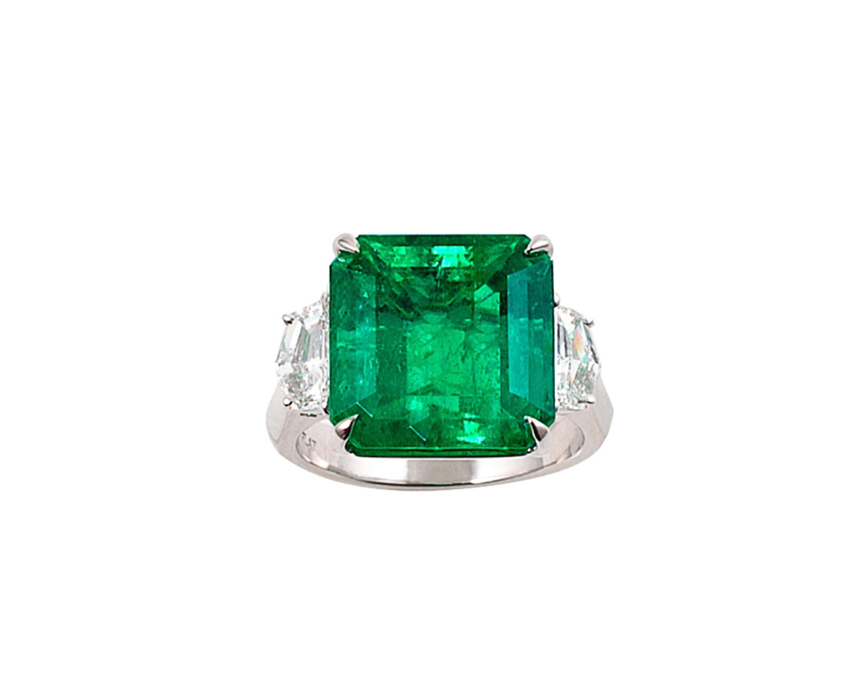 Magnificent emerald, diamond and platinum ring, centering 1 four prong-set, emerald-cut, square emerald with 2 four prong-set step-cut modified triangular diamonds. Excellent color and clarity on diamonds. Comes with certificate and appraisal.