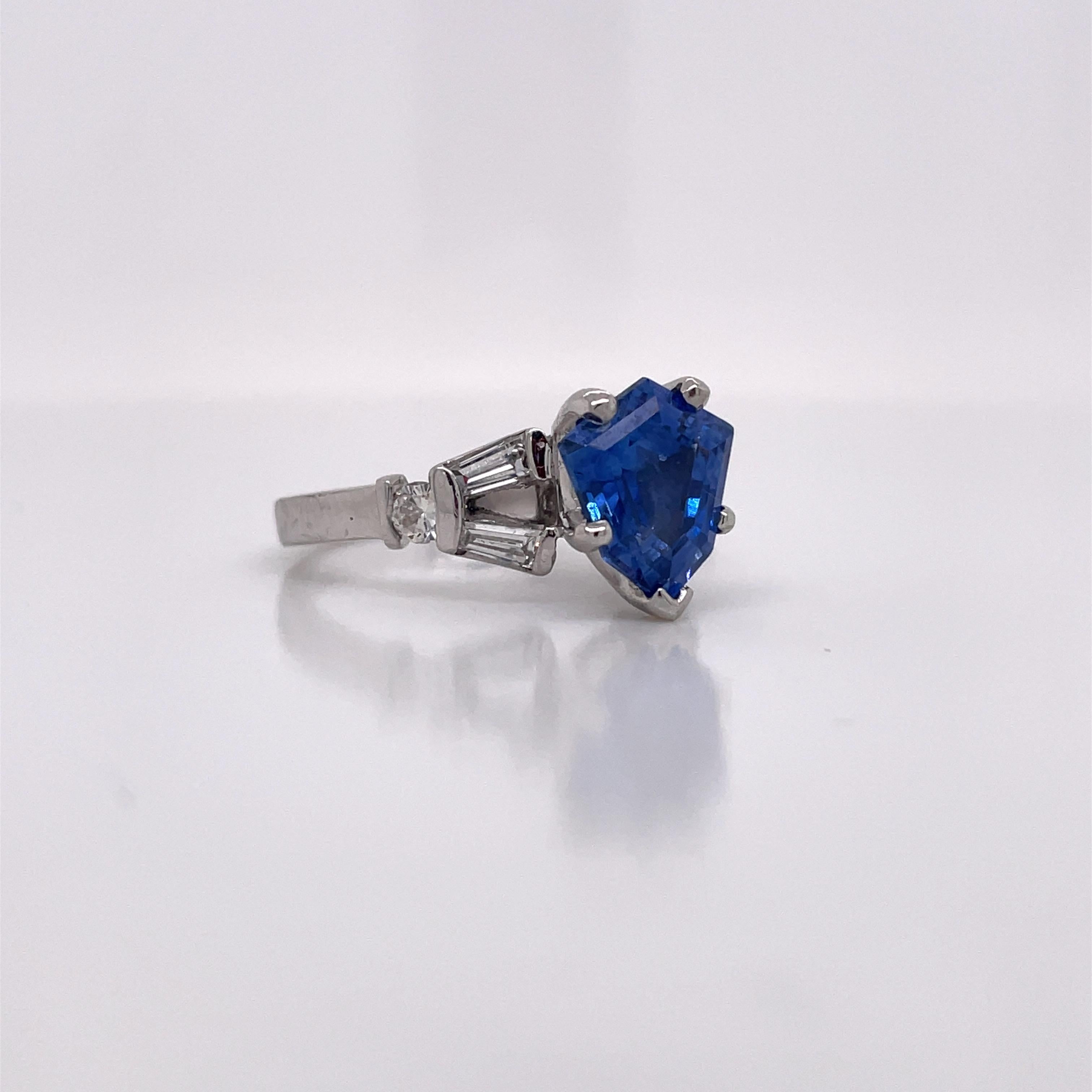 This is an absolutely breathtaking AGL Certified Sapphire Ring adorned with gorgeous tapered baguettes set in platinum! You won't find a ring quite like this! The center stone is an absolutely breathtaking 2.42ct shield-cut blue sapphire! Adorning