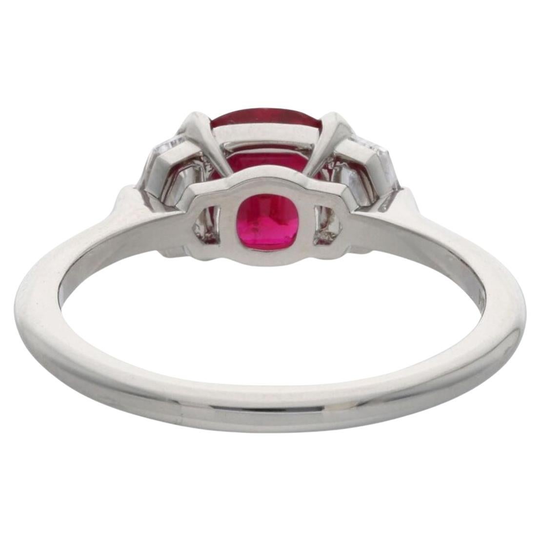 beautiful ring featuring a central ruby and two shield-cut diamonds set in platinum. Here's a breakdown of the details provided:

Ruby: The central ruby weighs 1.41 carats. It is described as red in color, originating from Burma (now known as