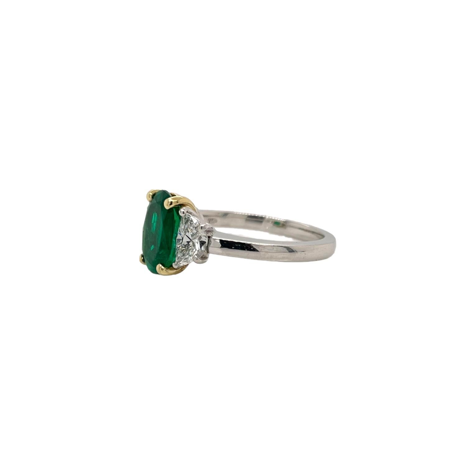 Ring contains one AGL certified Colombian green emerald, 1.70ct and two side half-moon cut diamonds, 0.70tcw.
Diamonds are G in color and VS2 in clarity. Stones are mounted in a handmade basket prong setting in 18k yellow gold and platinum band.