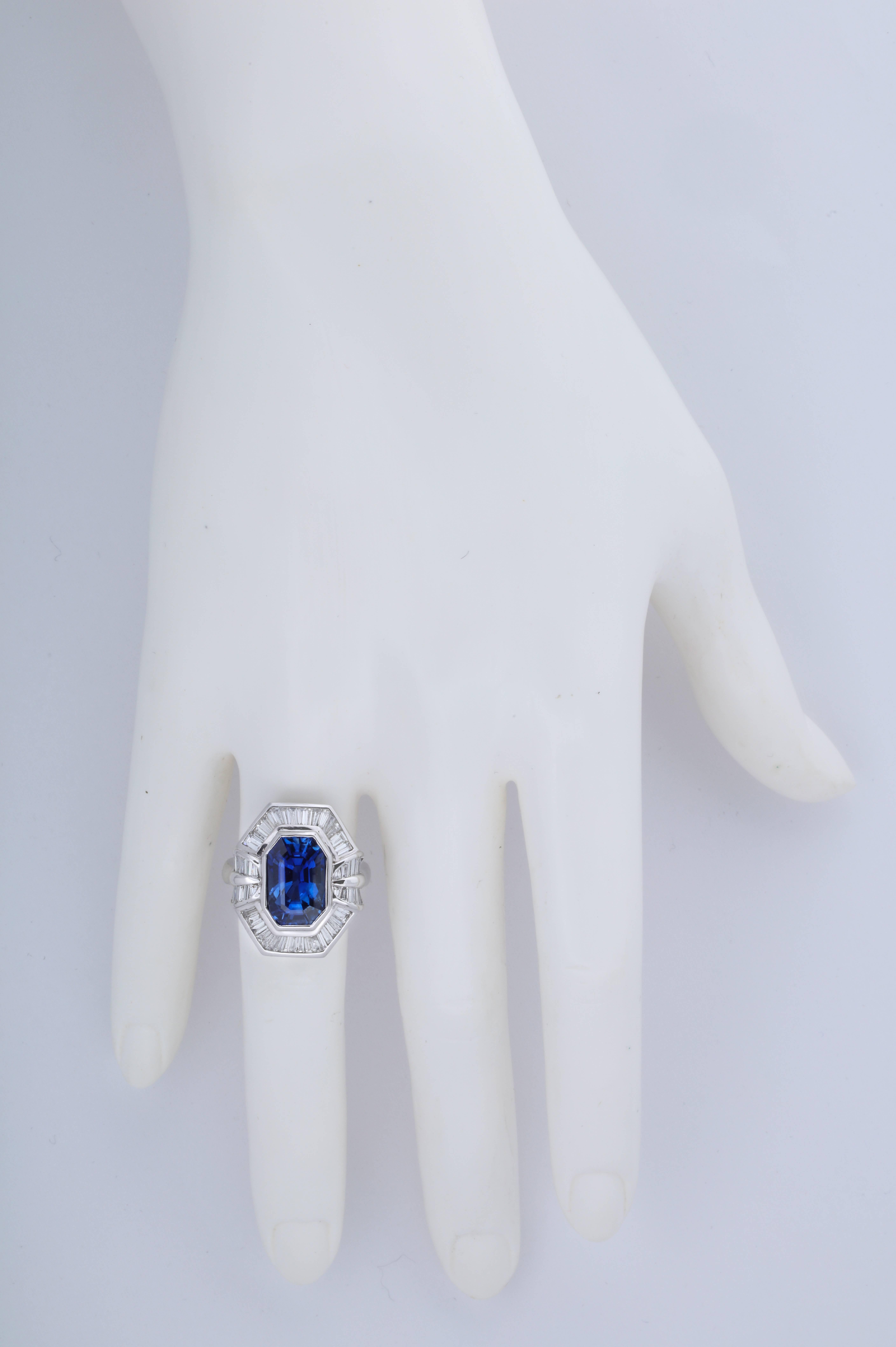 The long emerald cut shape is wonderfully elegant and it works perfectly with the baguette diamonds in the mounting.  The sapphire weighs app. 8 carats and there are app. 2.20 carats of fine, white baguette diamonds.

The ring was was made in one of