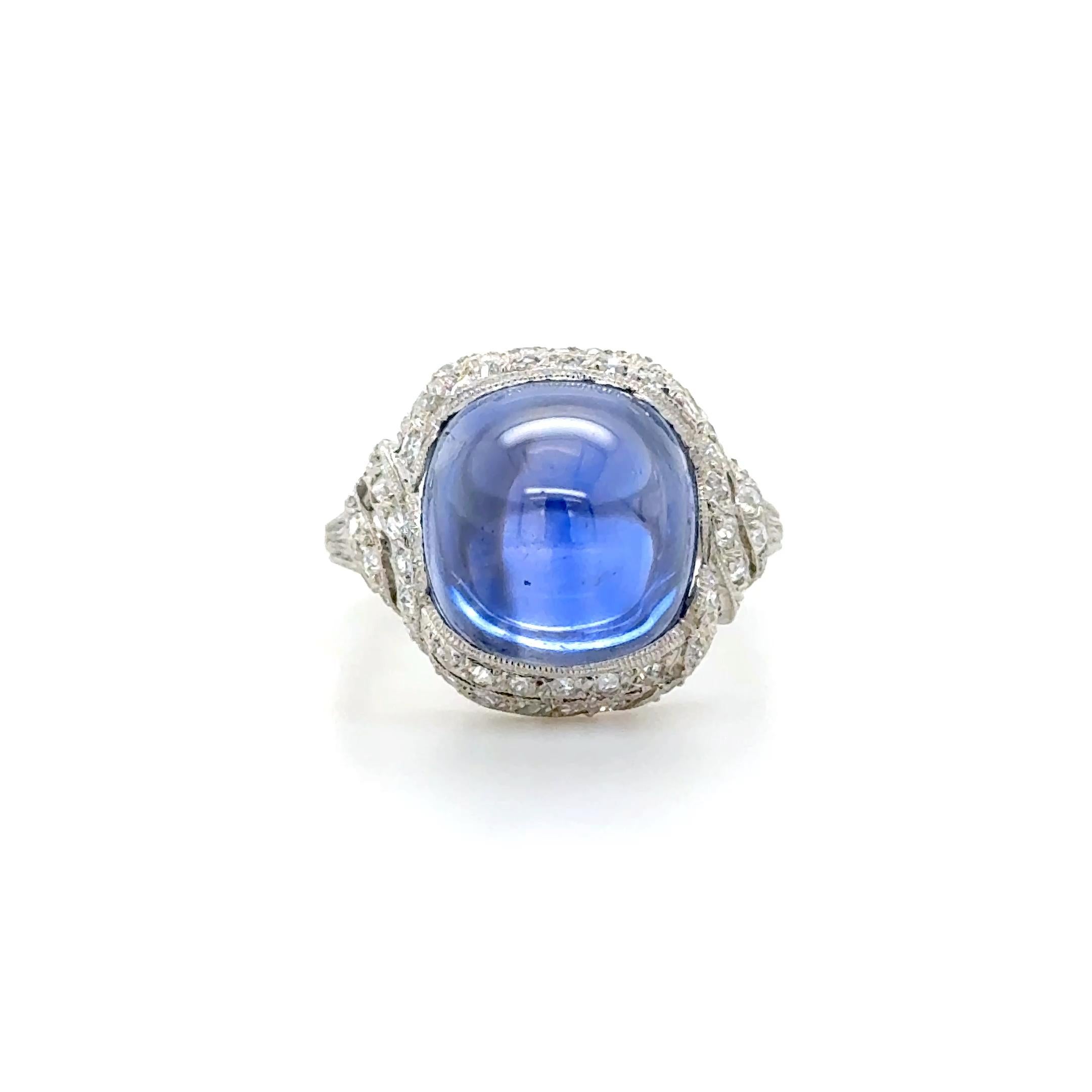 This stunning ring contains a cushion cabochon cut sapphire weighing approximately 9.46 carats surrounded by numerous single cut diamonds. Mounted in a beautifully engraved handmade Edwardian platinum mounting.

AGL, 2024, Report No. 1144123, 9.46