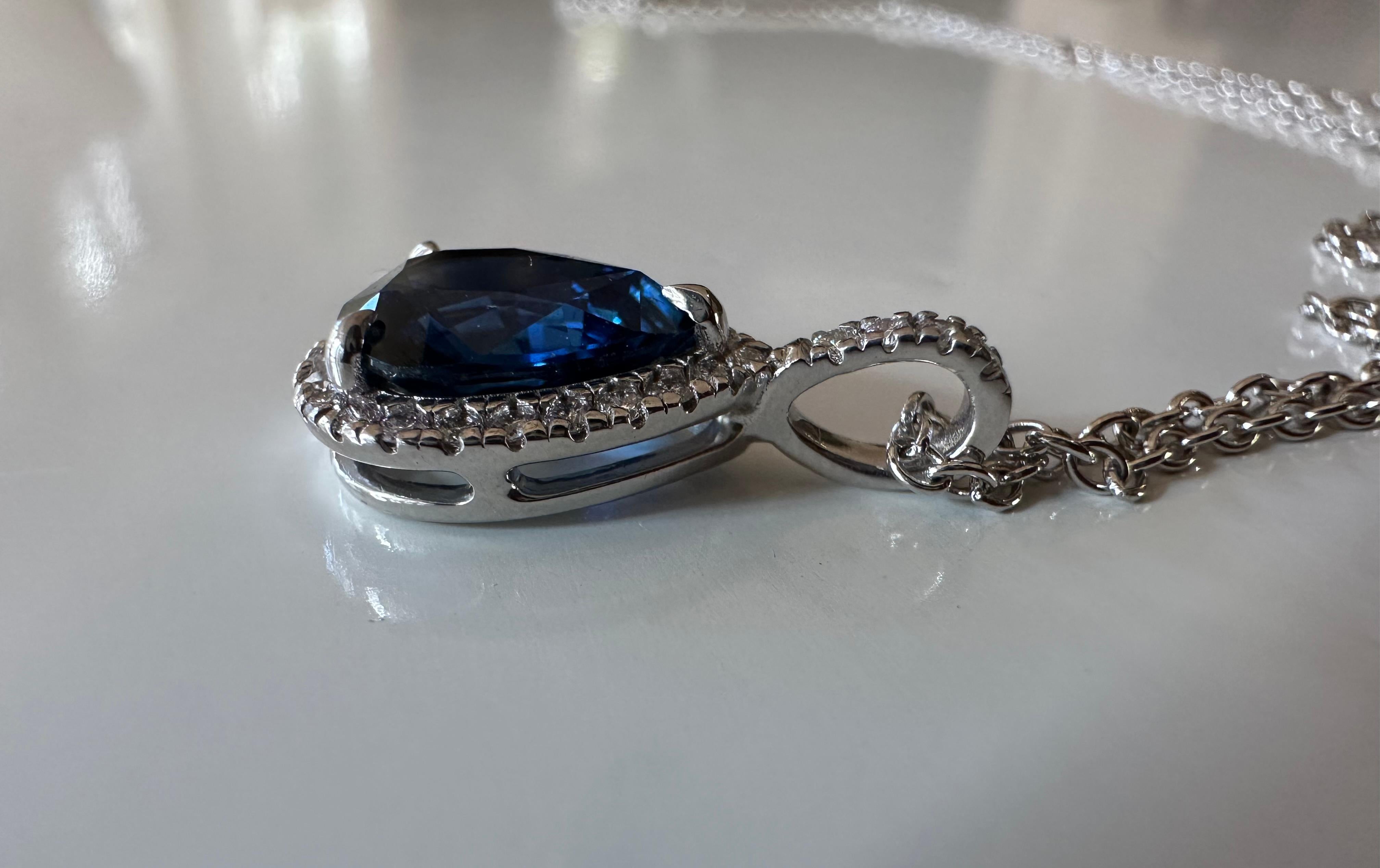 A 2.83-carat pear-shaped natural blue sapphire centers this exquisite pendant necklace handcrafted in 14K white gold and surrounded by a halo of twenty-seven round diamonds, G color, SI1 clarity totaling 0.22 carats. The sapphire, completely natural