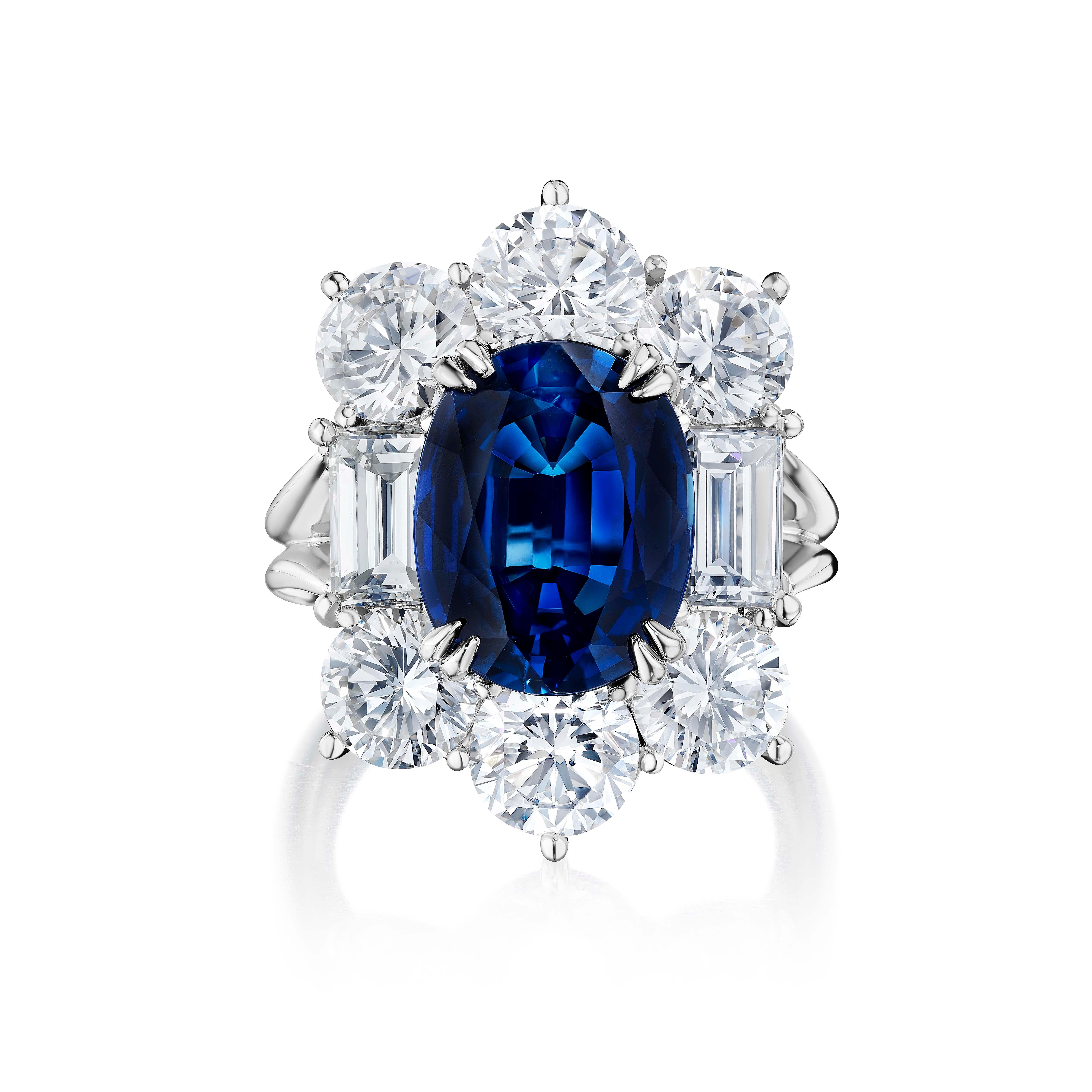 Centered upon a 6.30 Carat unheated Sapphire of Thai origin. Accompanied with AGL certificate.
Surrounded by Round and Emerald Cut Diamonds weighing 6.65 Carats.
Set in Platinum.
Finger size 6.5