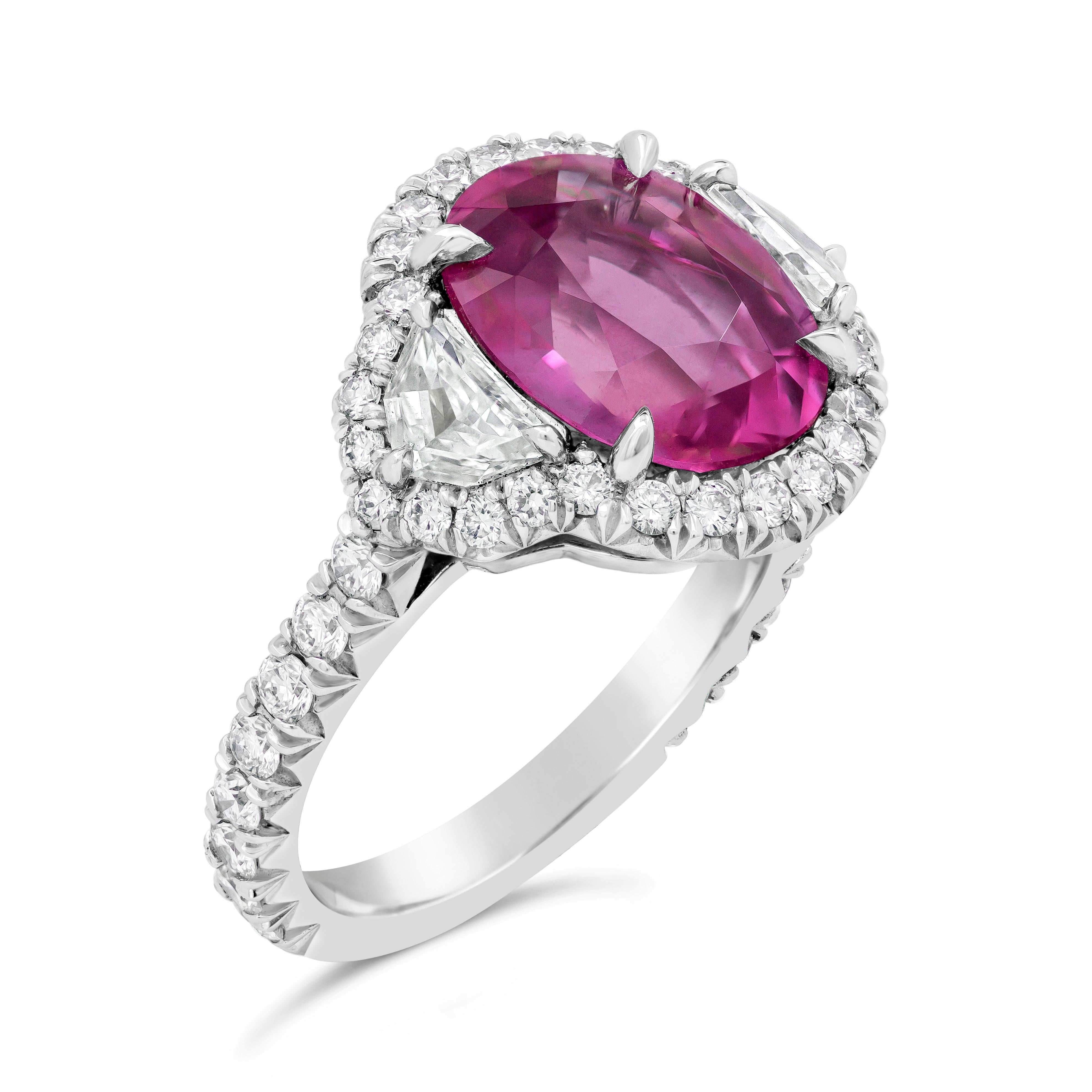 A charming three stone engagement ring style showcasing a AGL Certified oval cut pink sapphire weighing 5.73 carat total. Flanked on each side are epaulette diamonds weighing 0.56 carats. Surrounded and accented by brilliant round diamonds in a halo