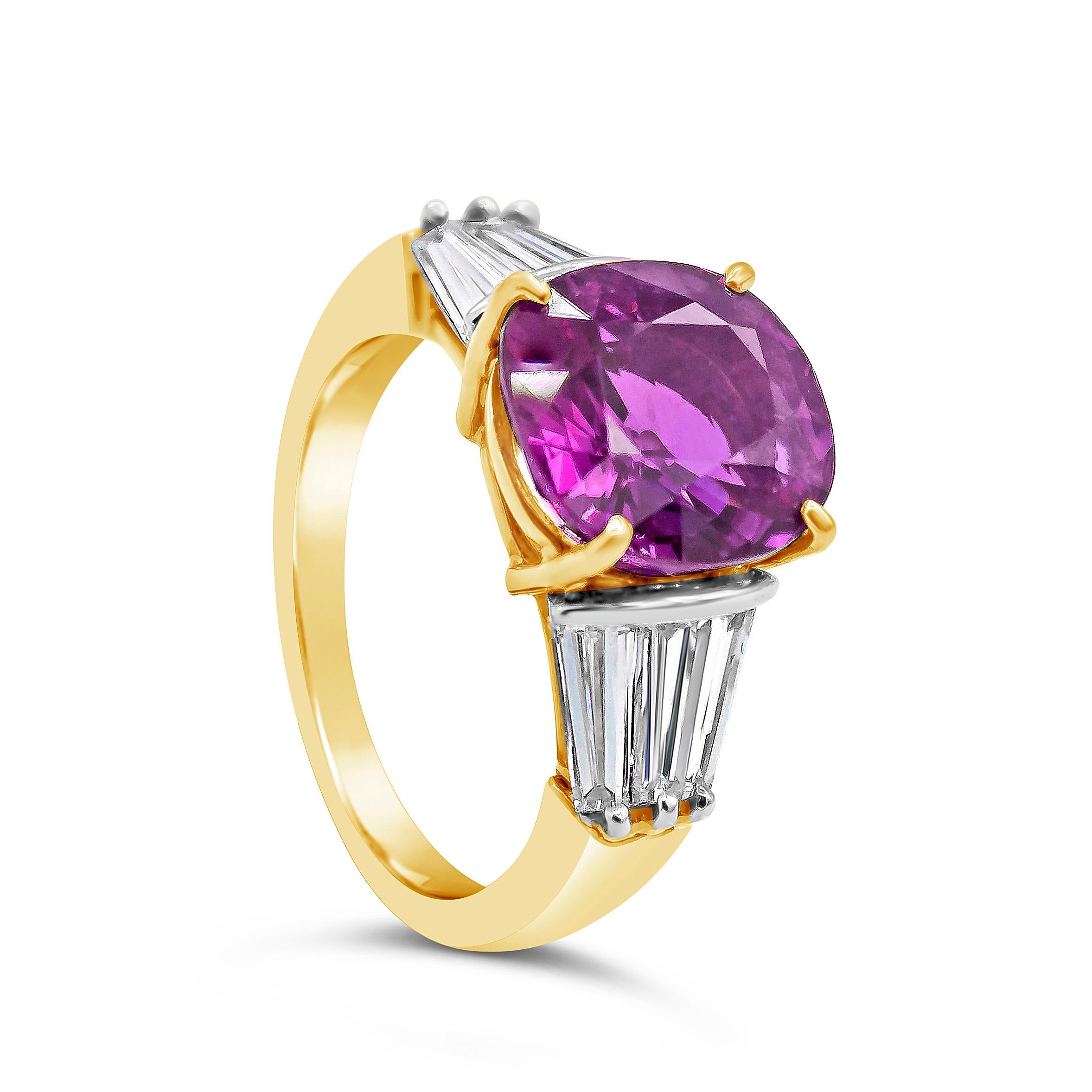 Well crafted three stone engagement ring showcasing a natural color-rich 4.95 carat no heat purple pink sapphire gemstone, VVS in clarity. Set on a four prong 18k yellow gold basket, flanked by three invisibly set tapered baguette diamonds on each