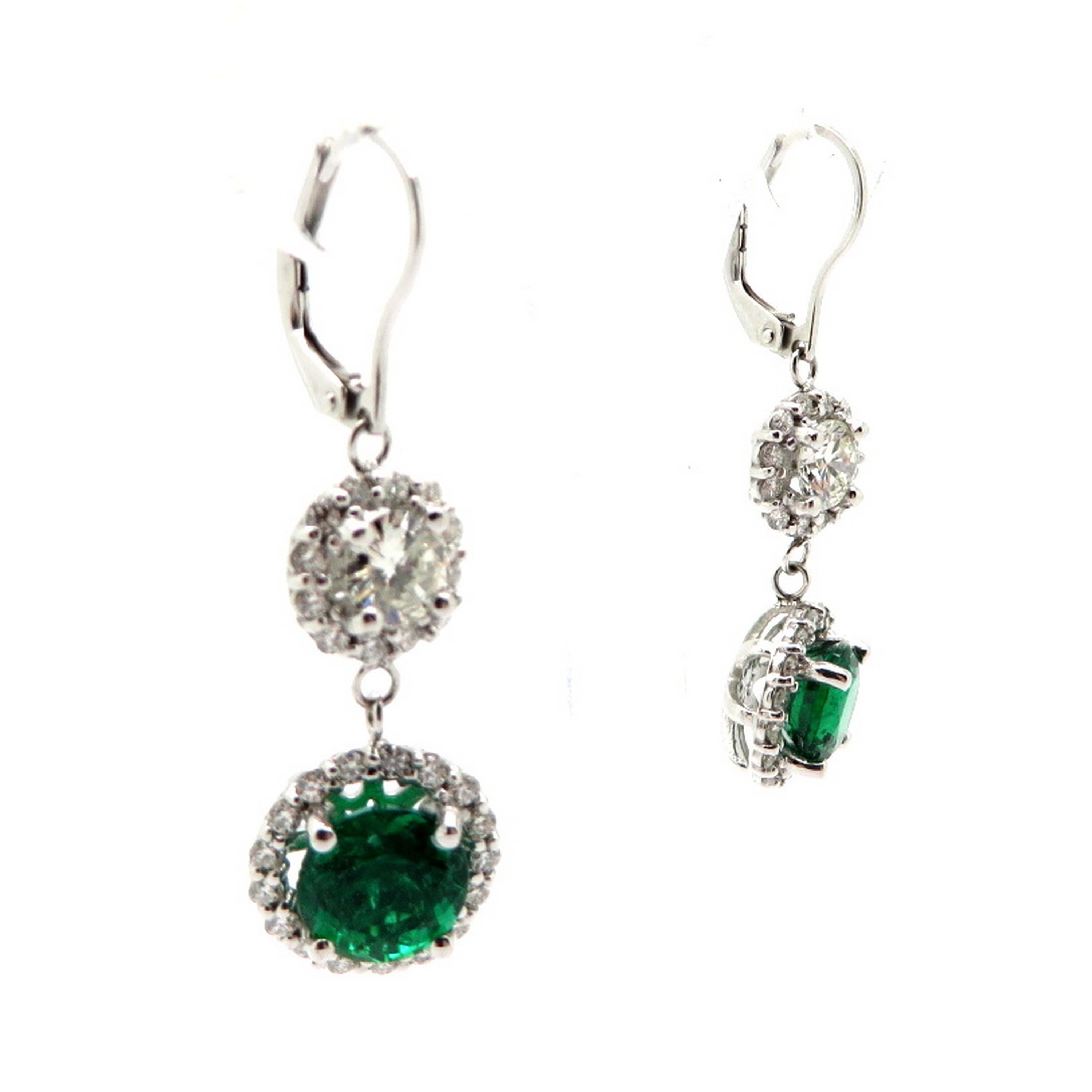 AGL certified Zambian emerald and diamond 14K white gold dangle earrings. Featuring two round brilliant cut AGL certified Zambian emeralds weighing approximately 3.85 carats total. Accented with 60 round brilliant cut prong set diamonds with a halo