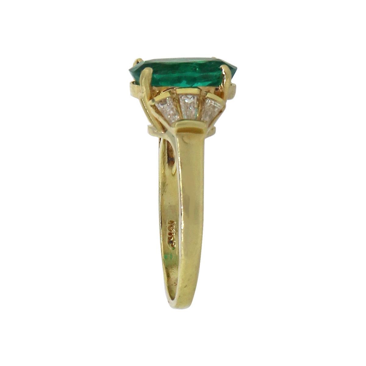Material: 18k Yellow Gold
Center  Gemstone Details: 4.07ct oval cut emerald. AGL #1101100
Adjacent Diamond Details: Approx. 0.70ctw of baguette cut diamonds. Diamonds are G/H in color and VS in clarity
Ring Size: 8
Ring Measurements: 0.80″ x 0.47″ x