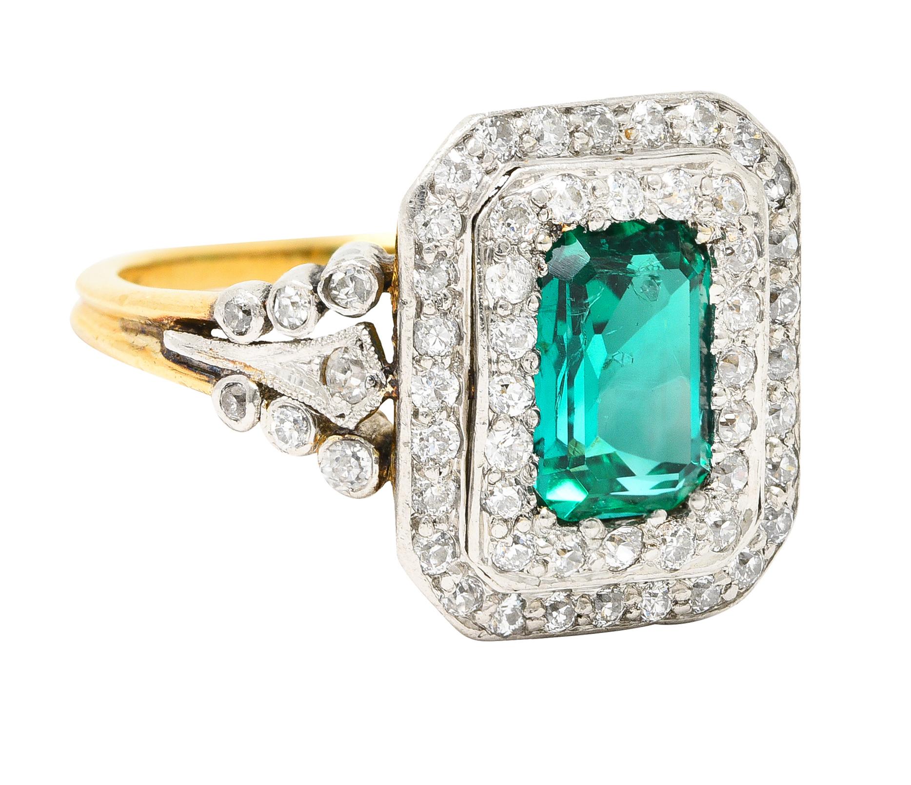 Centering an emerald cut emerald weighing 1.38 carats total - transparent medium green in color. Natural Colombian in origin with minor traditional clarity enhancement - bead set. With a stepped double halo surround of old European and single cut