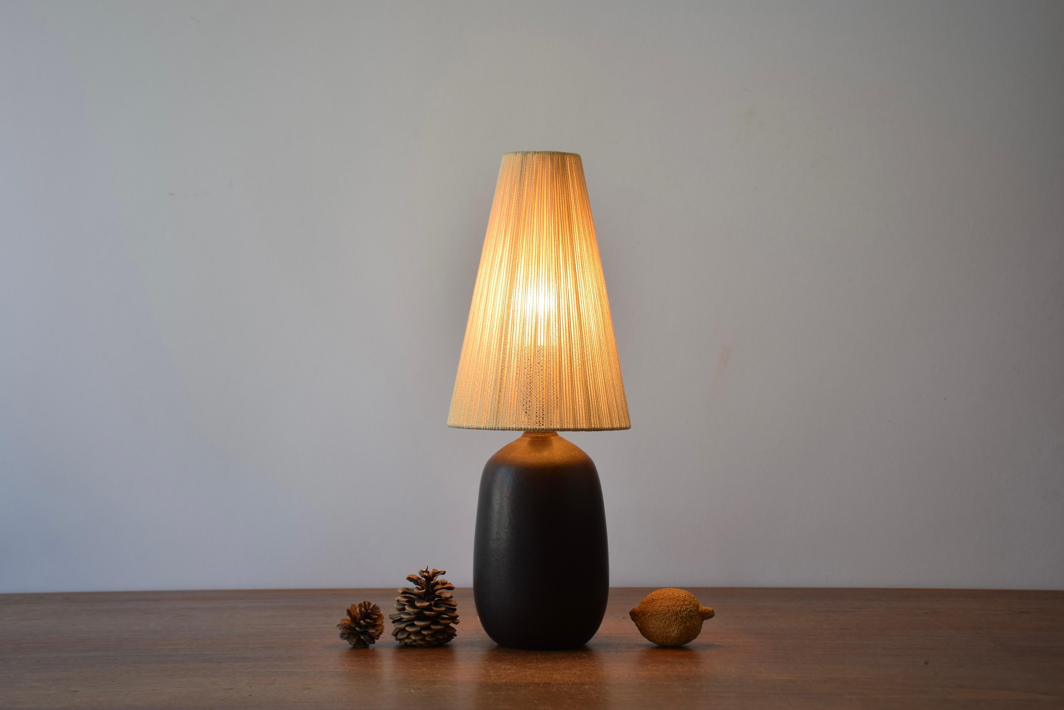 Kleine Keramik-Tischlampe des schwedischen Designers und Keramikers Agne Aronsson (1924-1990), hergestellt in seinem eigenen Studio in Bjärnum um 1960. 

Die Lampe wird mit einem Vintage-Lampenschirm geliefert, der höchstwahrscheinlich das Original