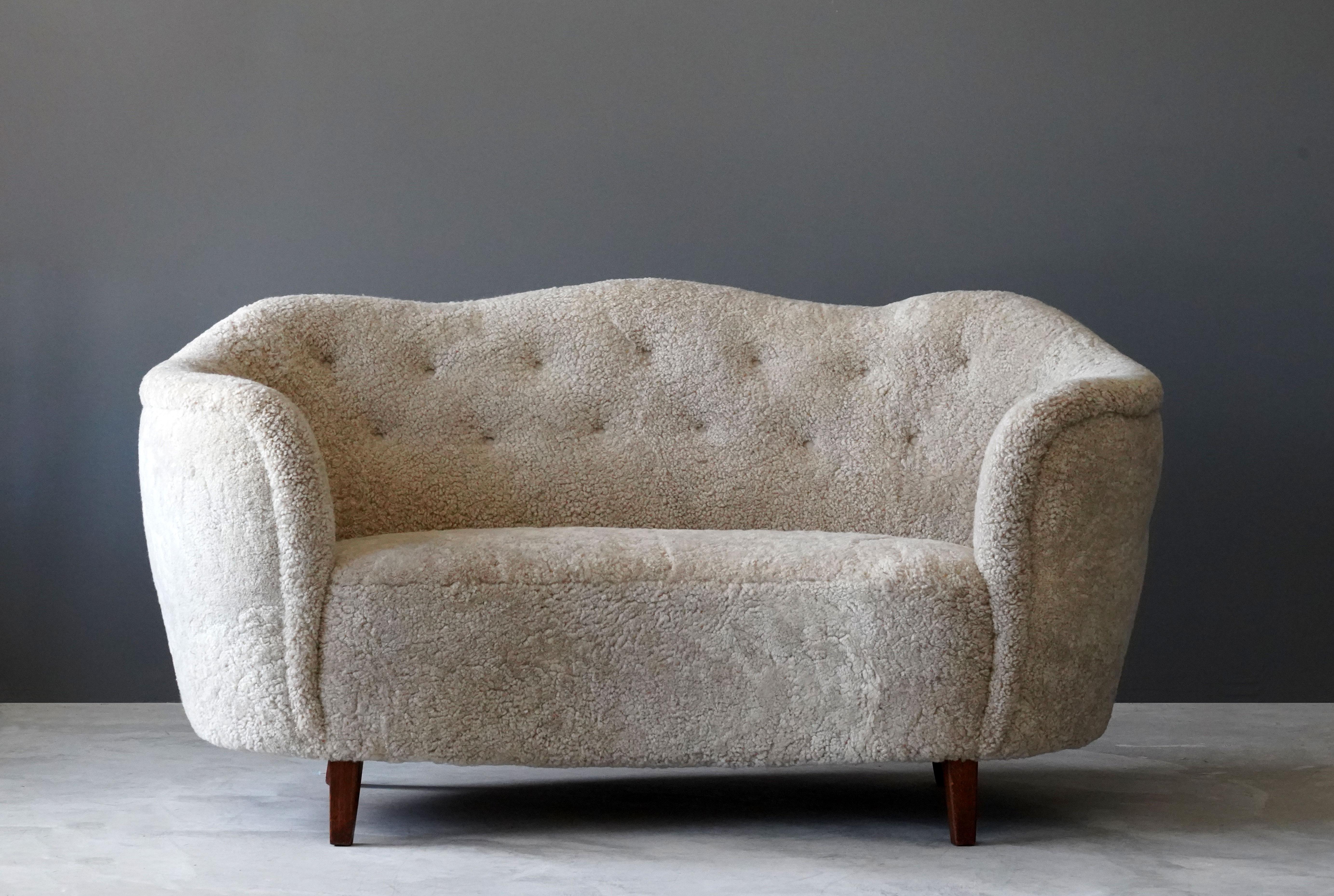An early Danish modernist sofa / loveseat with an organic form. Design attributed to Agner Christoffersen. Reference image available upon request. 

Presumably manufactured by N,C. Christoffersen, circa 1949, Denmark. 

 Other designers working