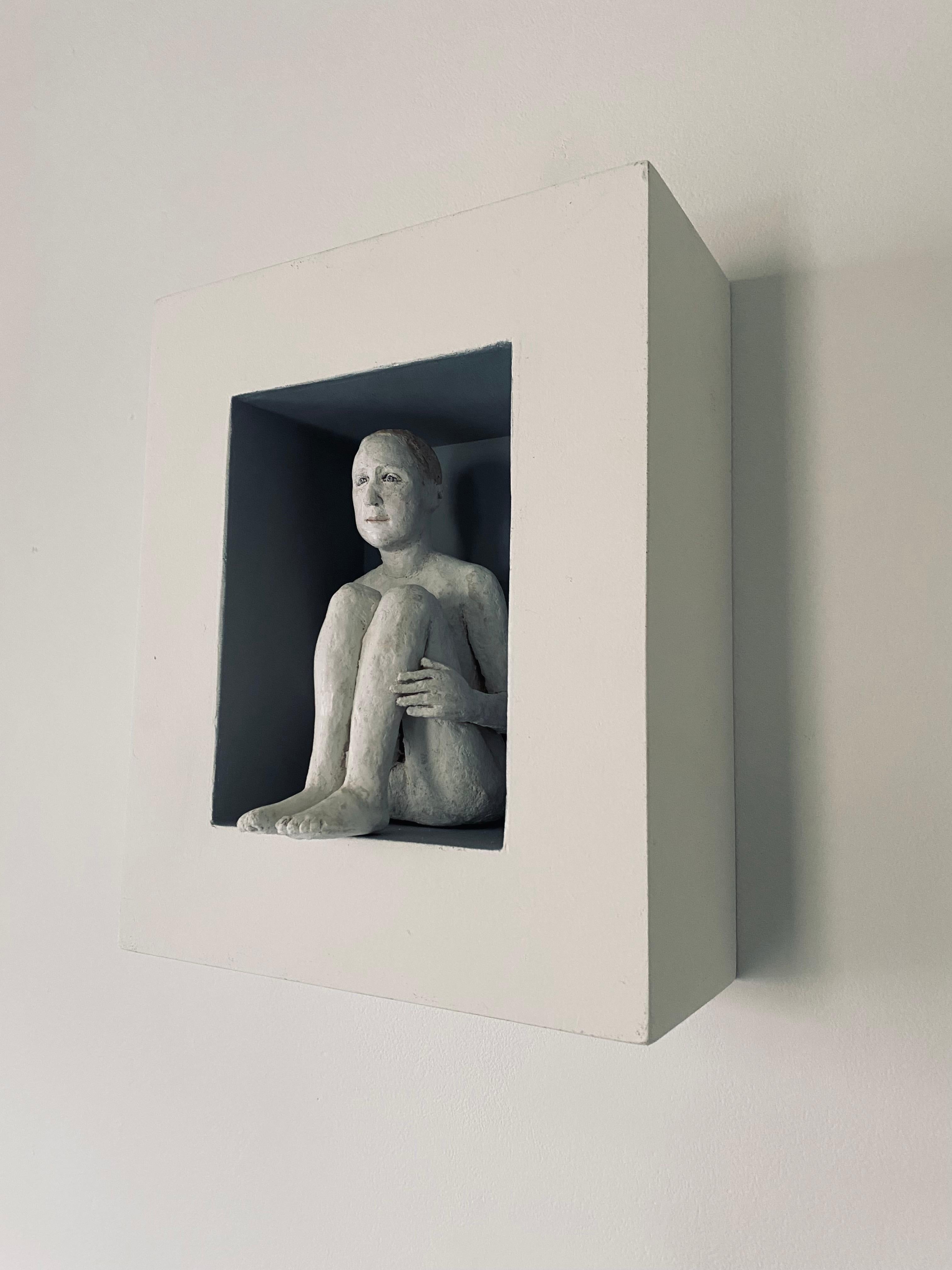 Wall sculpture of seated figure in box frame: Garcon sage dans une boîte - Sculpture by Agnes Baillon
