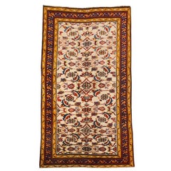 Tappeto Agra con colori rossi e gialli su sfondo beige.