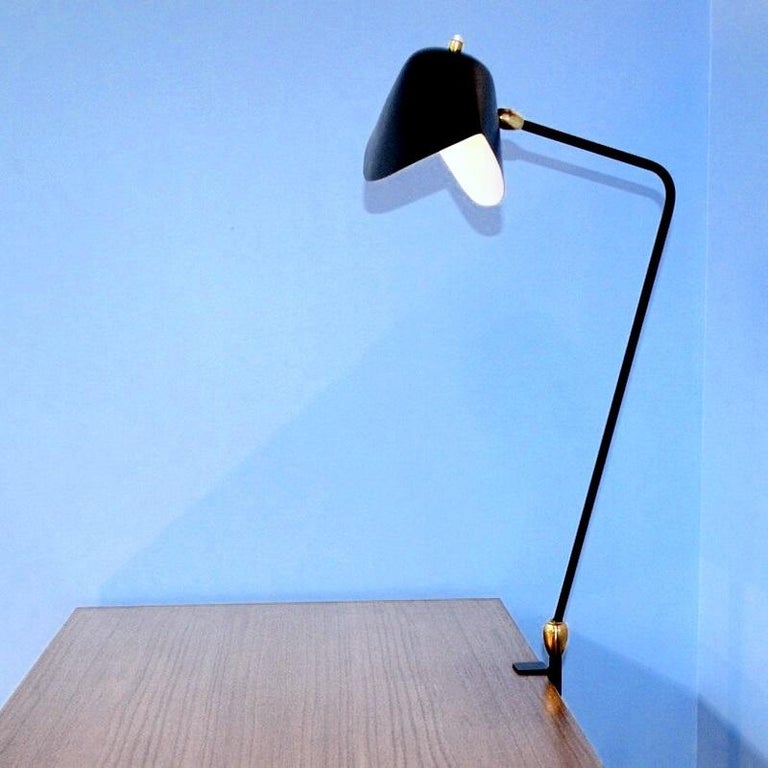 Clamp desk lamp with pivoting arm. At 26 inches at their highest, these lamps may affix to many surfaces providing direct lighting where it is needed.
Available in white or black. Brass swivels connect the shades.

Available in black or white. 