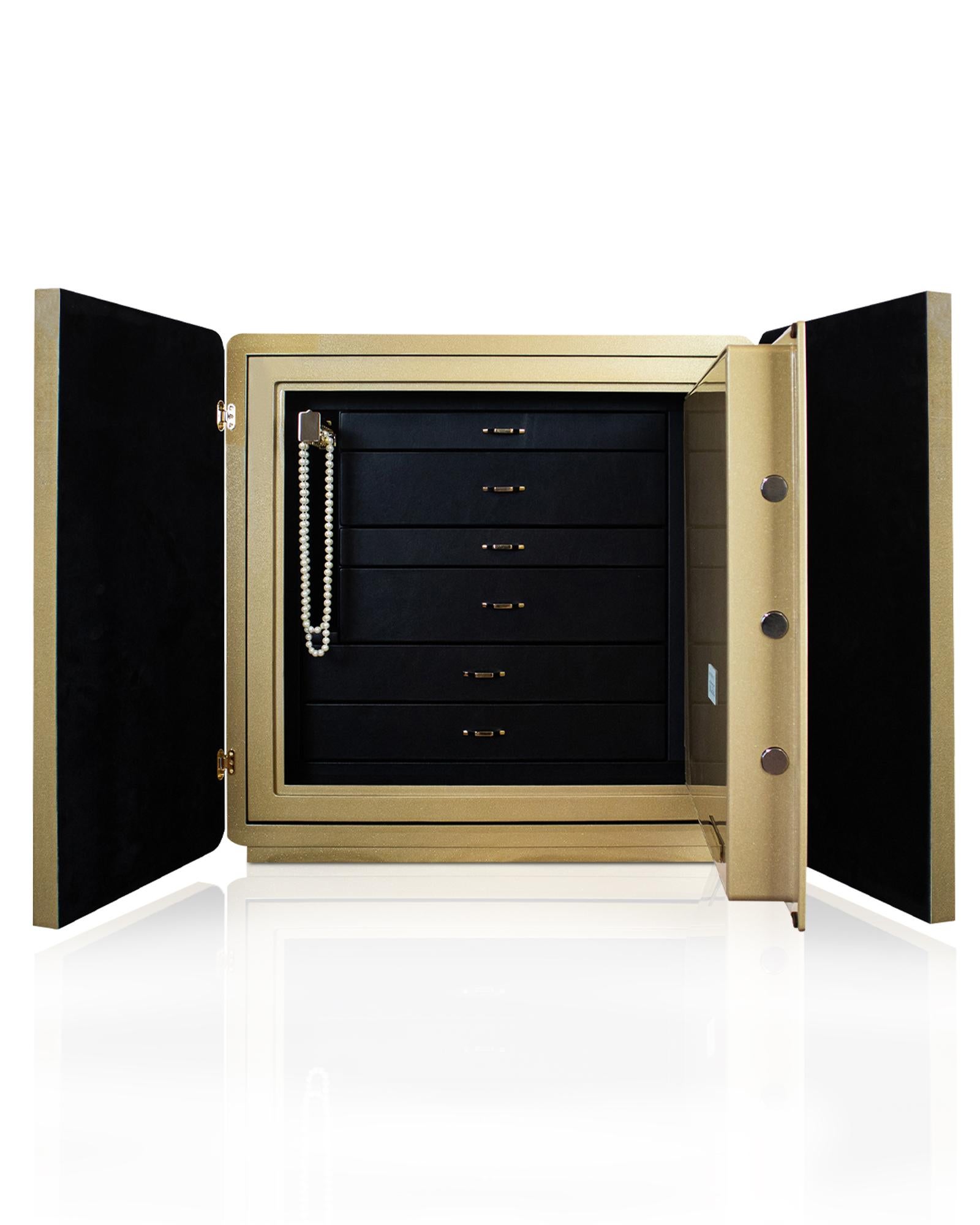 Armored jewelry cabinet covered in gold and black hand threaded leather. Varnished outside in
metallic gold color. Accessories in 24 karats gold plated brass. Drawers covered in black leather and inside lined with ultrasuede.
Inside a safe with
