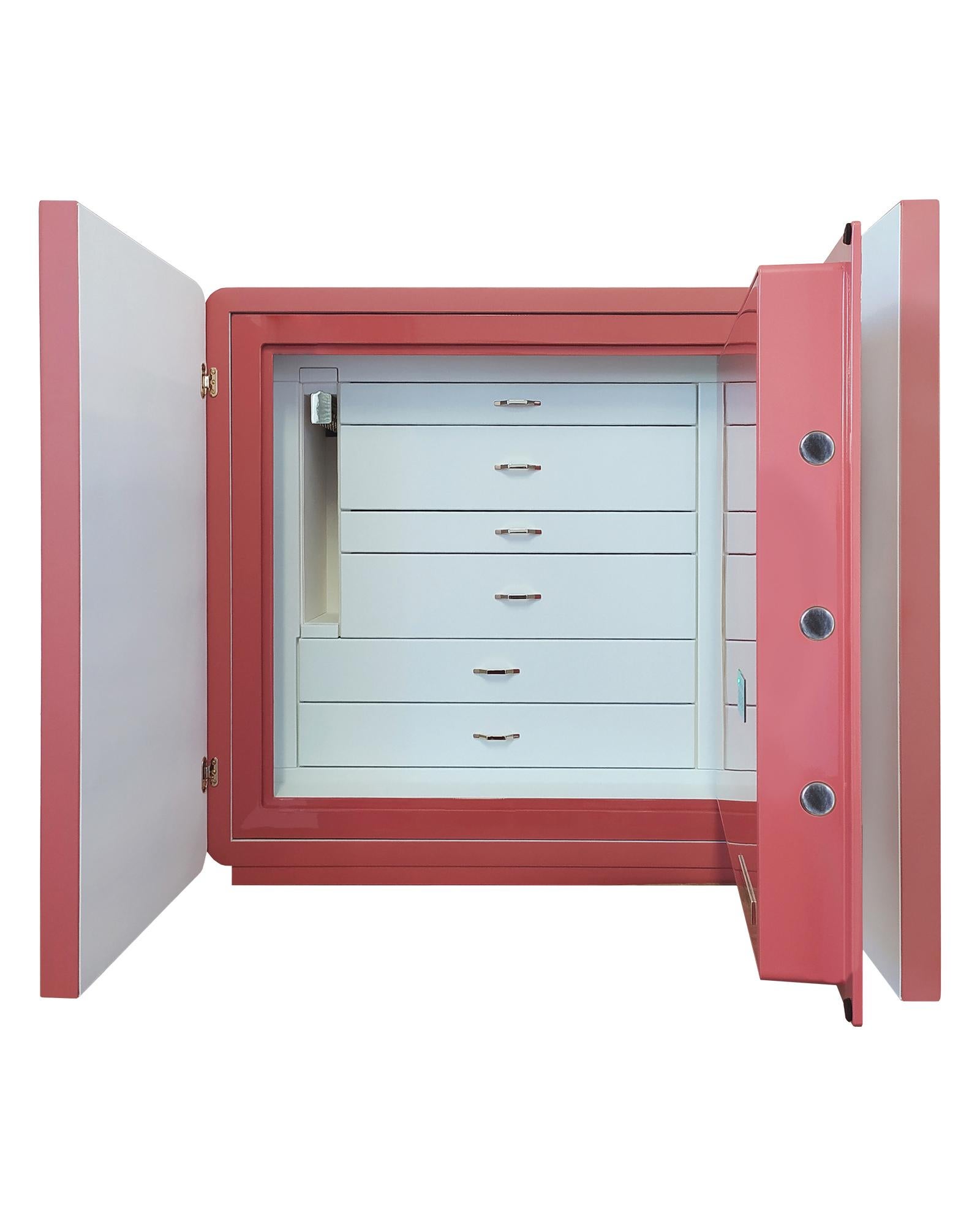 Armored jewelry cabinet covered in white and pink hand threaded leather. Varnished outside in pink color. Accessories in 24 karats gold plated brass. Drawers covered in white leather and inside lined with ultrasuede. Inside a safe with round handle