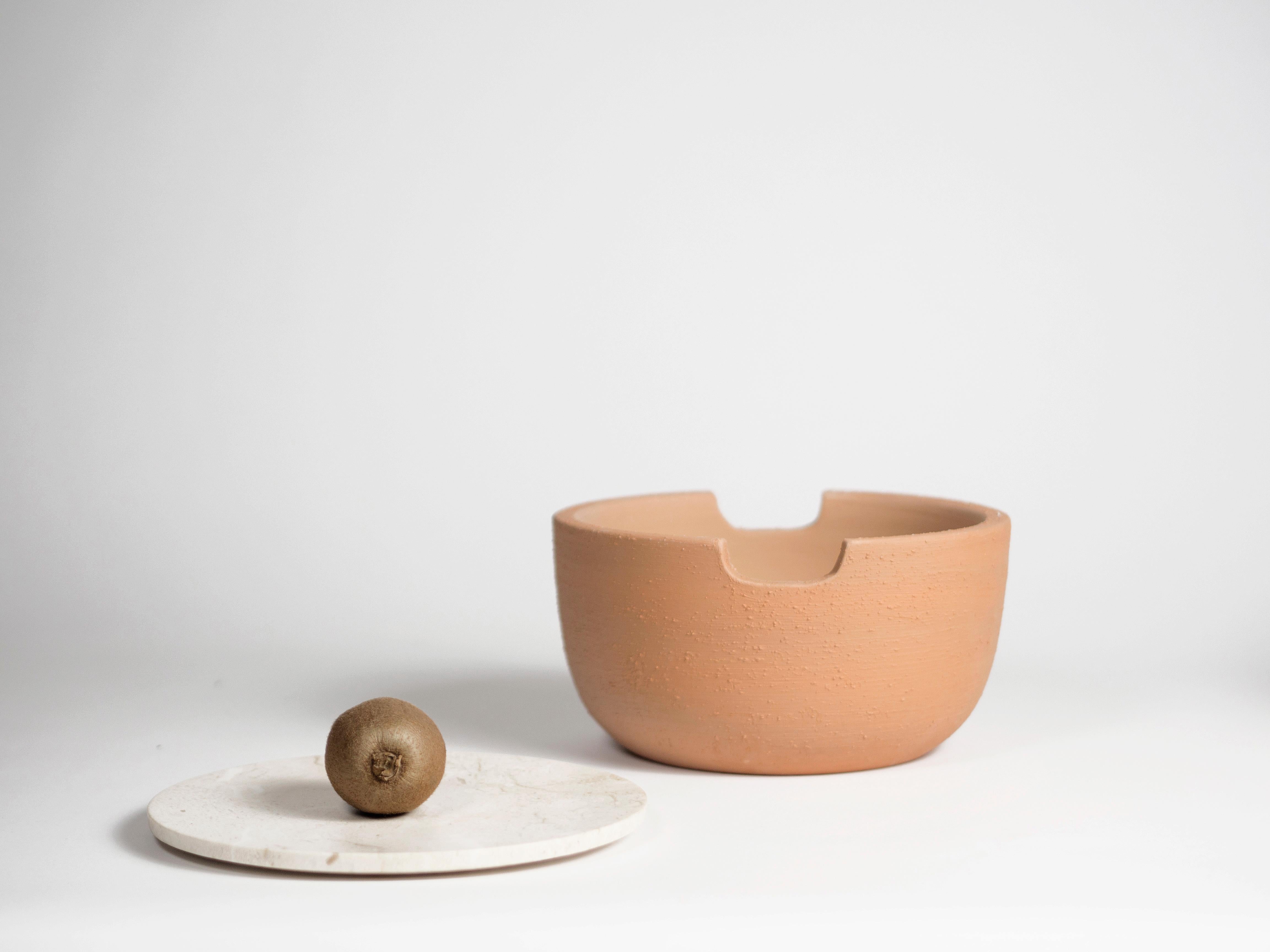 Fruit bowl in Sicilian stone and refractory terracotta, left natural. A reflection on the conservation of fruit and how to create an environment that prolongs the maturation process. Terracotta has the characteristic of being a thermal insulator, in