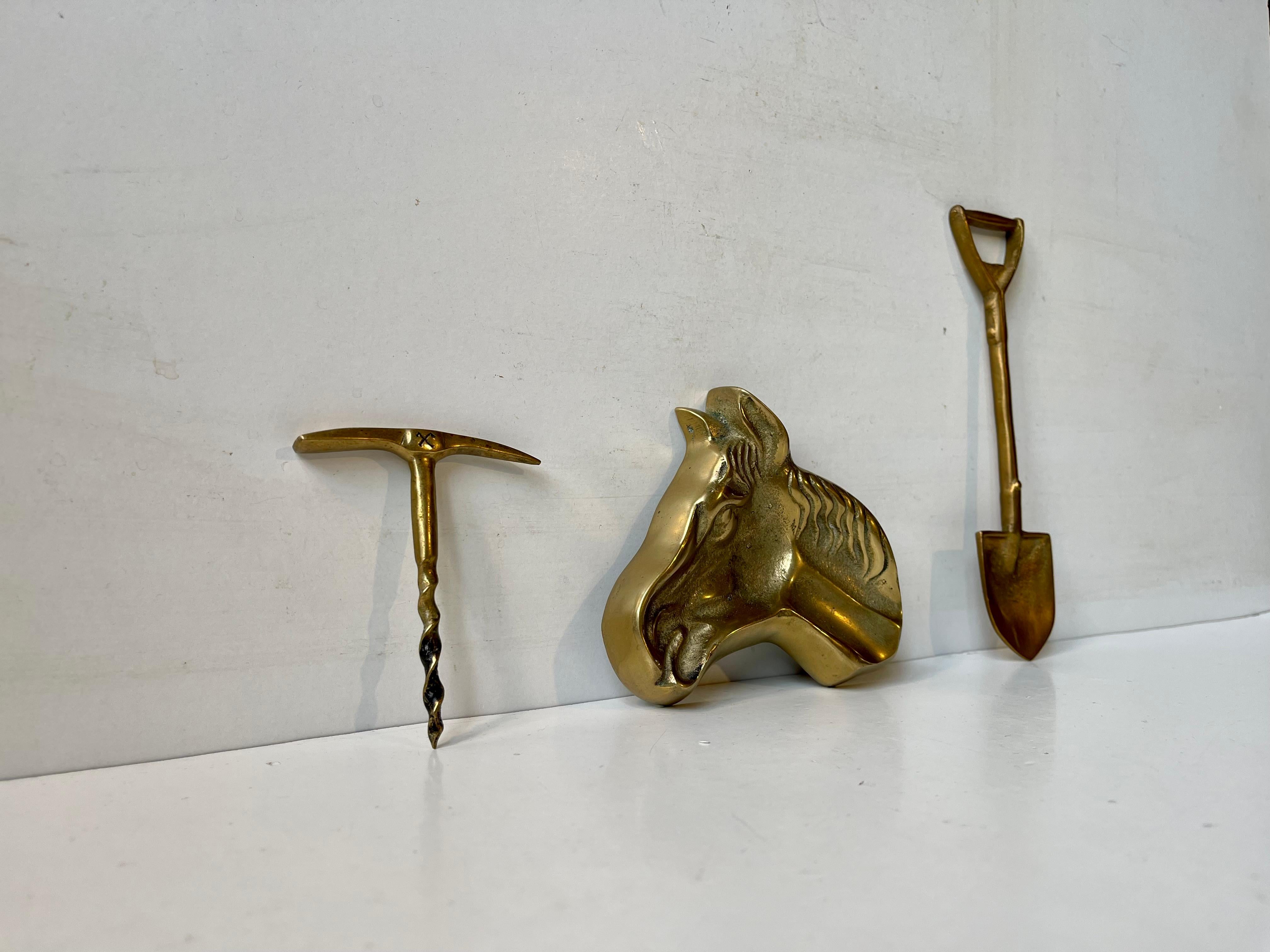Midcentury bar-set with the following accessories: a rock hammer Corkscrew, a spade shaped bottle opener and a horse head ashtray. All of them made from solid brass. Scandinavian made circa 1960-70. Measurements: H: 9/17 cm (mallet/spade). The