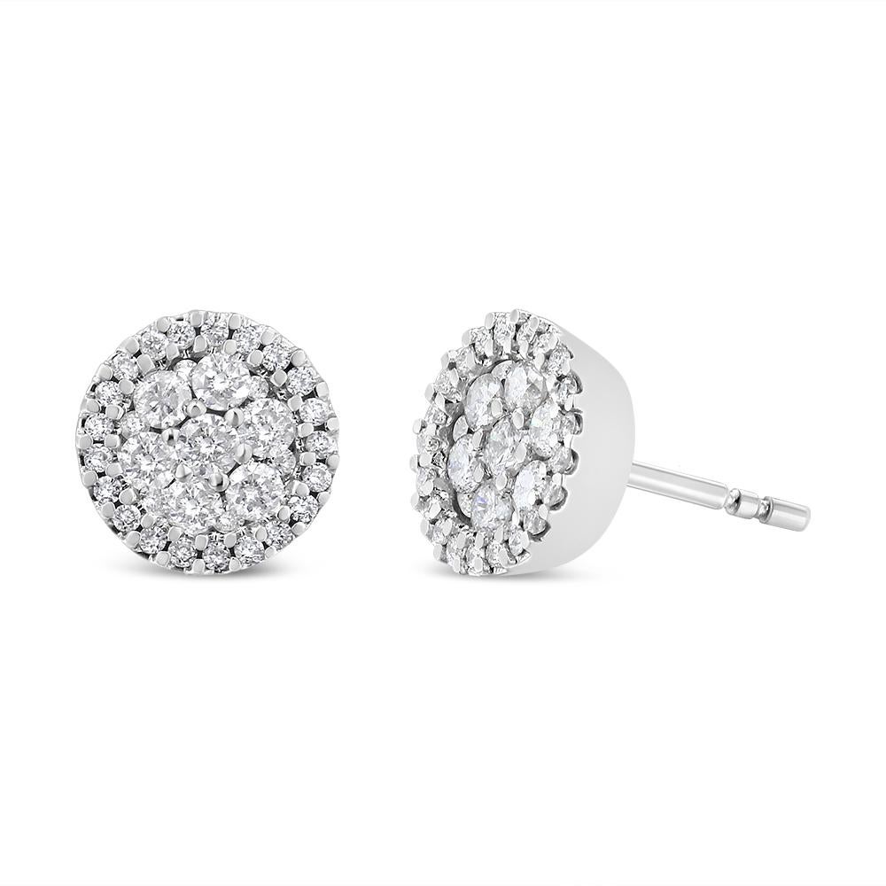 Elegant and timeless, these 14K white gold stud earrings feature round, brilliant cut diamonds in a halo style button shape. The earrings have three circular rows of diamonds of 1.0 carat total weight worth of diamonds. The earrings feature pushback