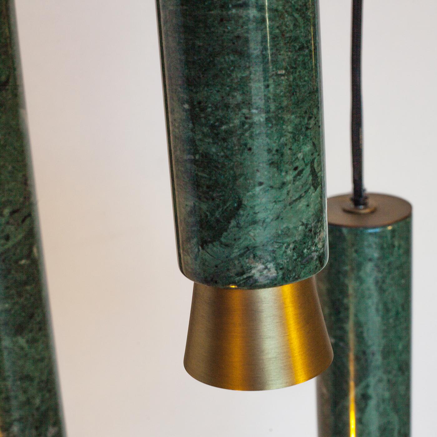 This beautiful 3 lights suspension lamp is part of the Agua collection. The pendant lamp is made of three pieces of different lengths. The structure is made of bronzed brass, while the three bodies of the lamp are made of green Guatemala marble. \n