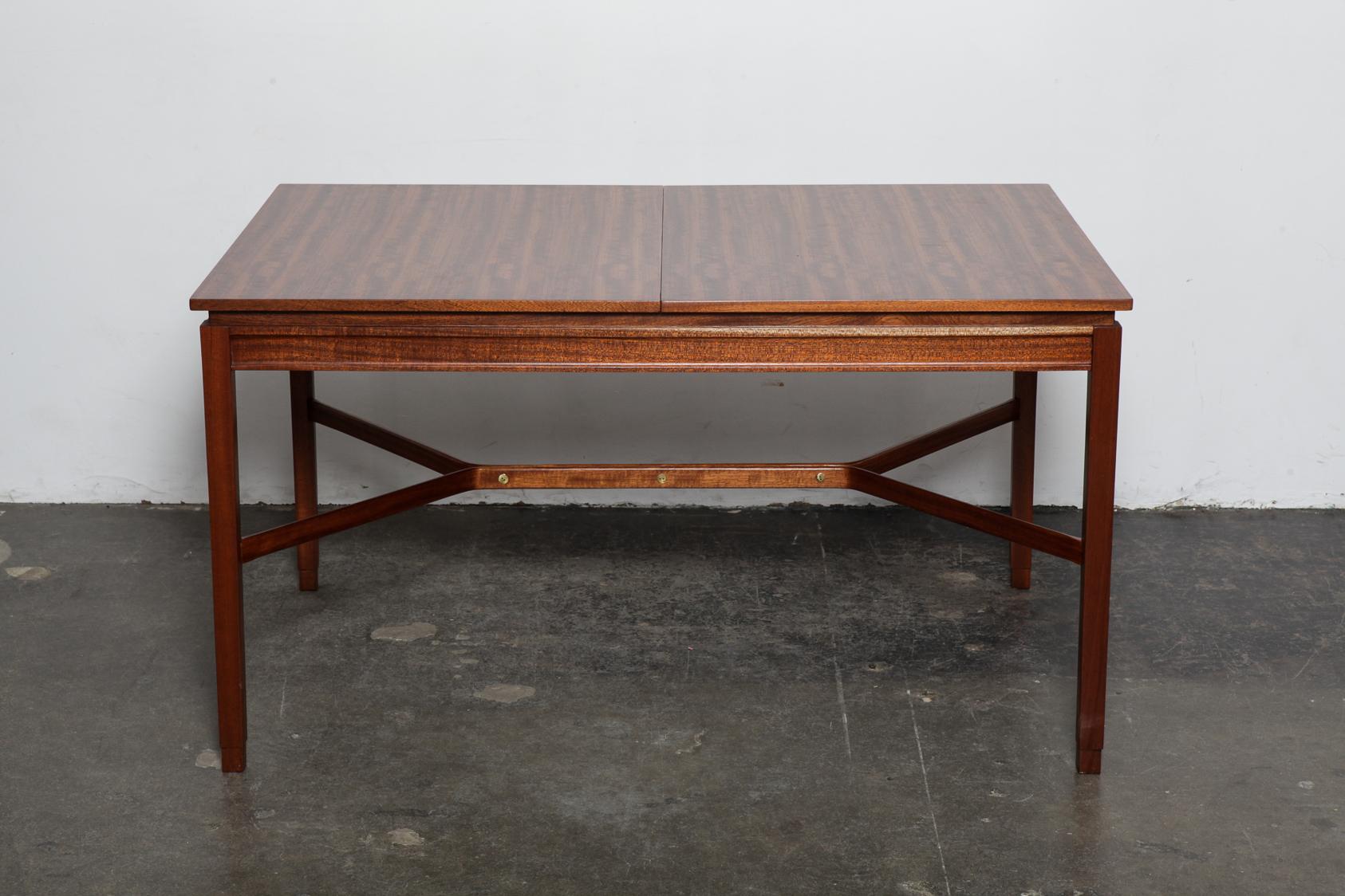 Scottish made rectangular mahogany dining table with one center extension, parson style legs and a very interesting center cross support, 1950s. When fully extended it is 78