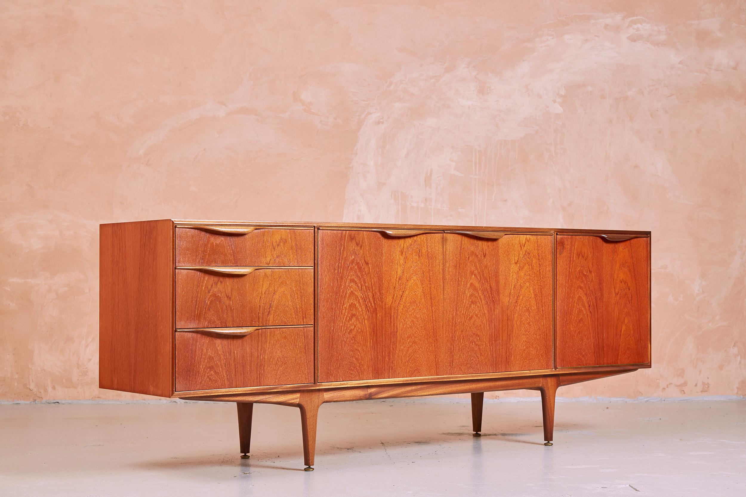 Vintage teak McIntosh sideboard, circa 1960s. Features 3 drawers, one main double door cupboard containing a fixed shelf, and a further cupboard with single drop down door, contain a bottle organiser and a pull out cocktail shelf.

An excellent