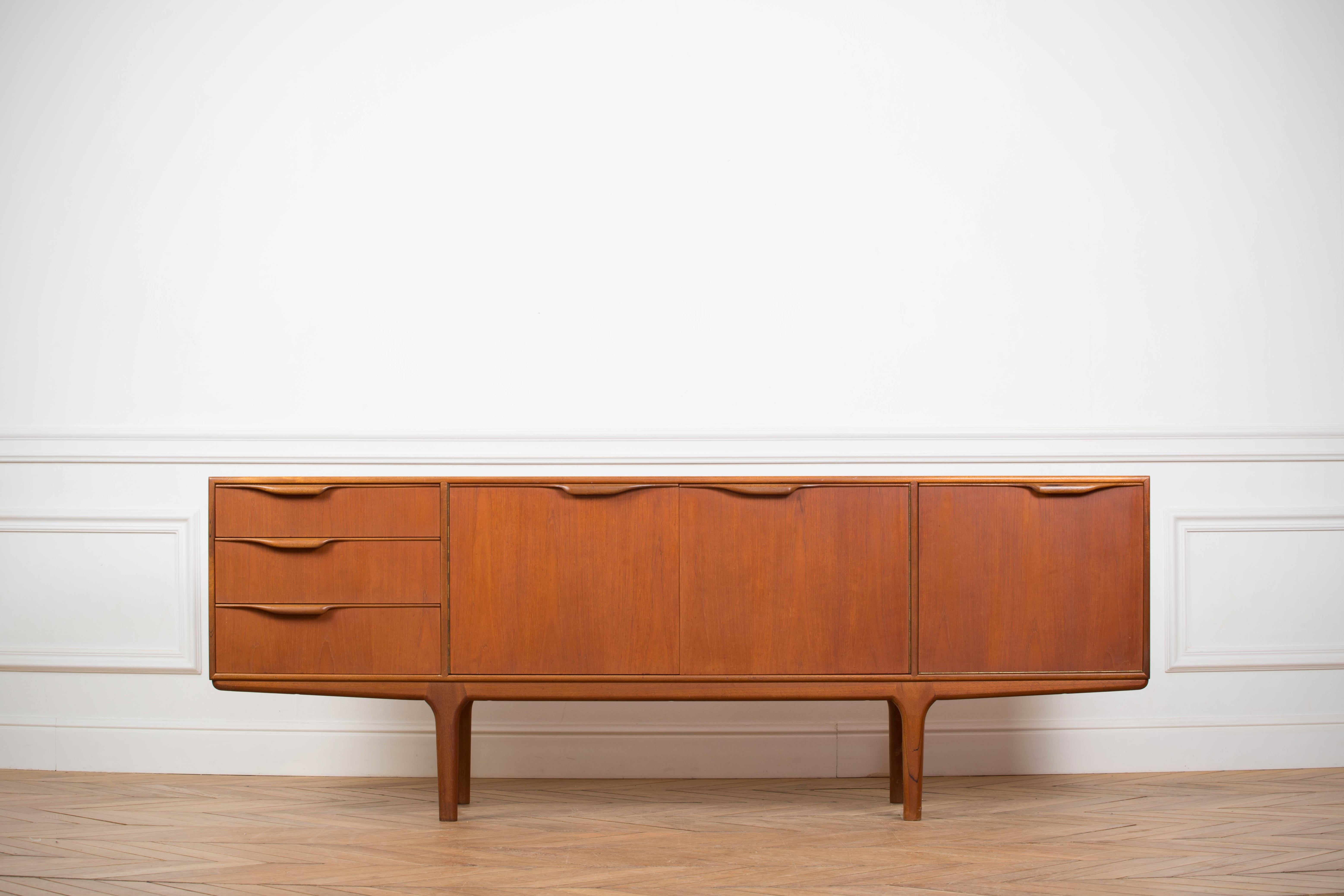 Stunning and beautifully crafted teak sideboard designed by Tom Robertson and manufactured by A.H. McIntosh of Kirkaldy, Scotland, 1960s. 
A.H. McIntosh created quality furniture which catered to the tastes of progressive 1960s middle class