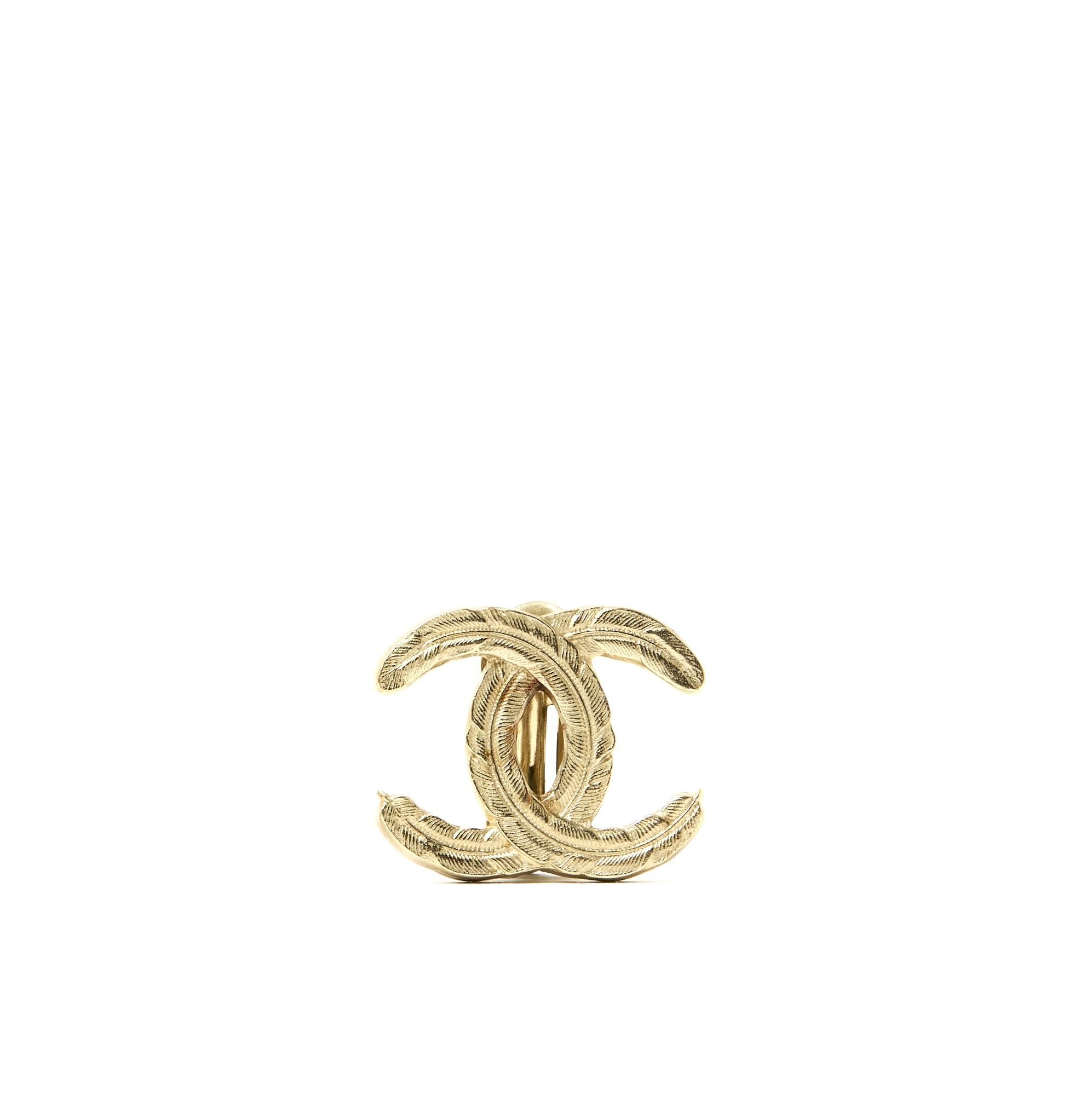 Chanel clip-on earrings from the AW2008 collection in pale gold metal (versus yellow gold) fashioned with the motif of a large CC initials in feathers. Width 2.65 cm x height 2.15 cm. The earrings show slight oxidation in the air which is not