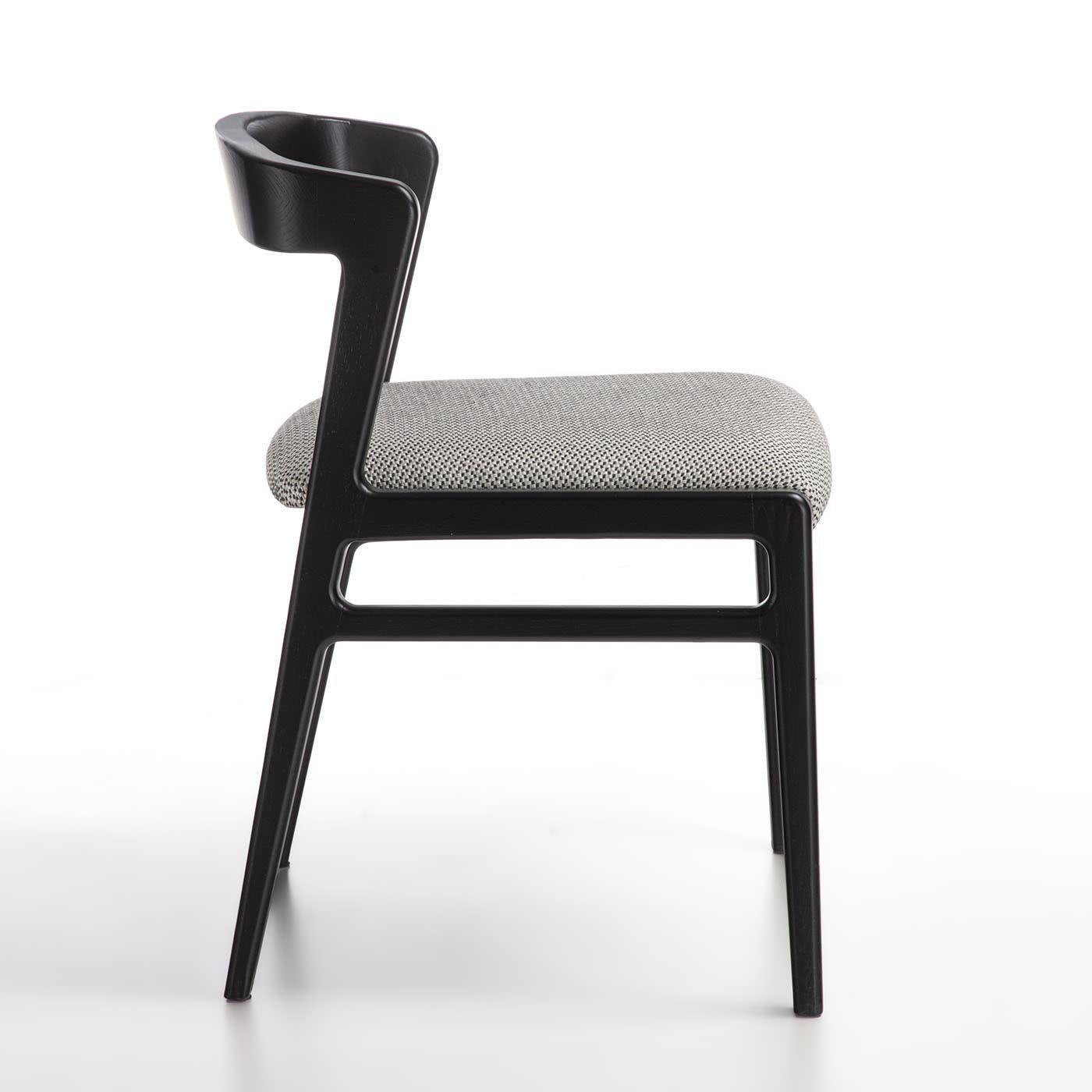 Chair from the Aida line with an essential and light design. Structure in solid wood and seat upholstered in fabric.