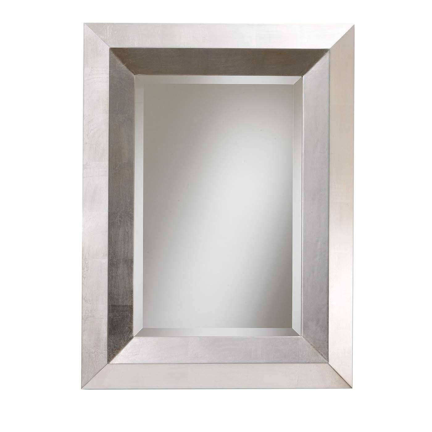 Marked by a bold and essential design, this wall mirror is fashioned of prized materials and can be custom made. The wooden frame is enriched by a hand-applied coating in silver leaf and encloses a rectangular mirror in Italian crystal with beveled