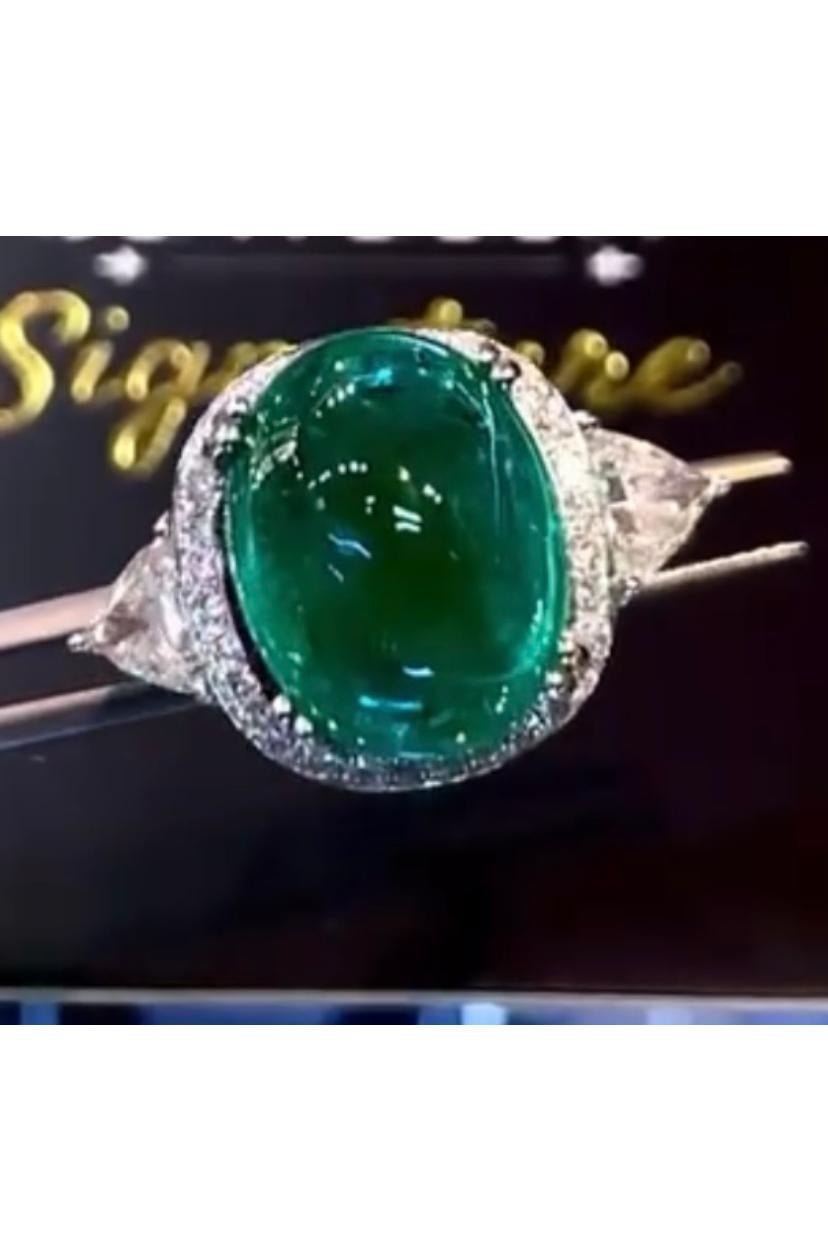 An exquisite contemporary design, so modern and elegant, a very adorable style.
Ring come in 18K gold with a natural Zambian Emerald, in perfect oval cabochon cut , fine quality, spectacular color , of 10,00  carats, and two side natural diamonds in