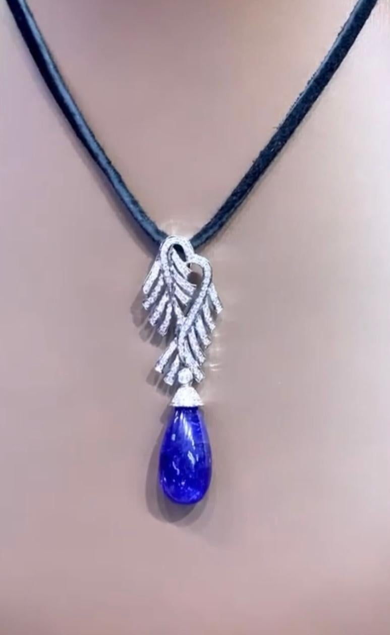 An amazing and original design for this particular pendant in 18k gold. 
Pendant come with a centre natural Tanzanite, cabochon cut, fine quality, 18,20 carats, and 104 pieces of natural diamonds in round brilliant cut, of 0,90 carats, F color VS