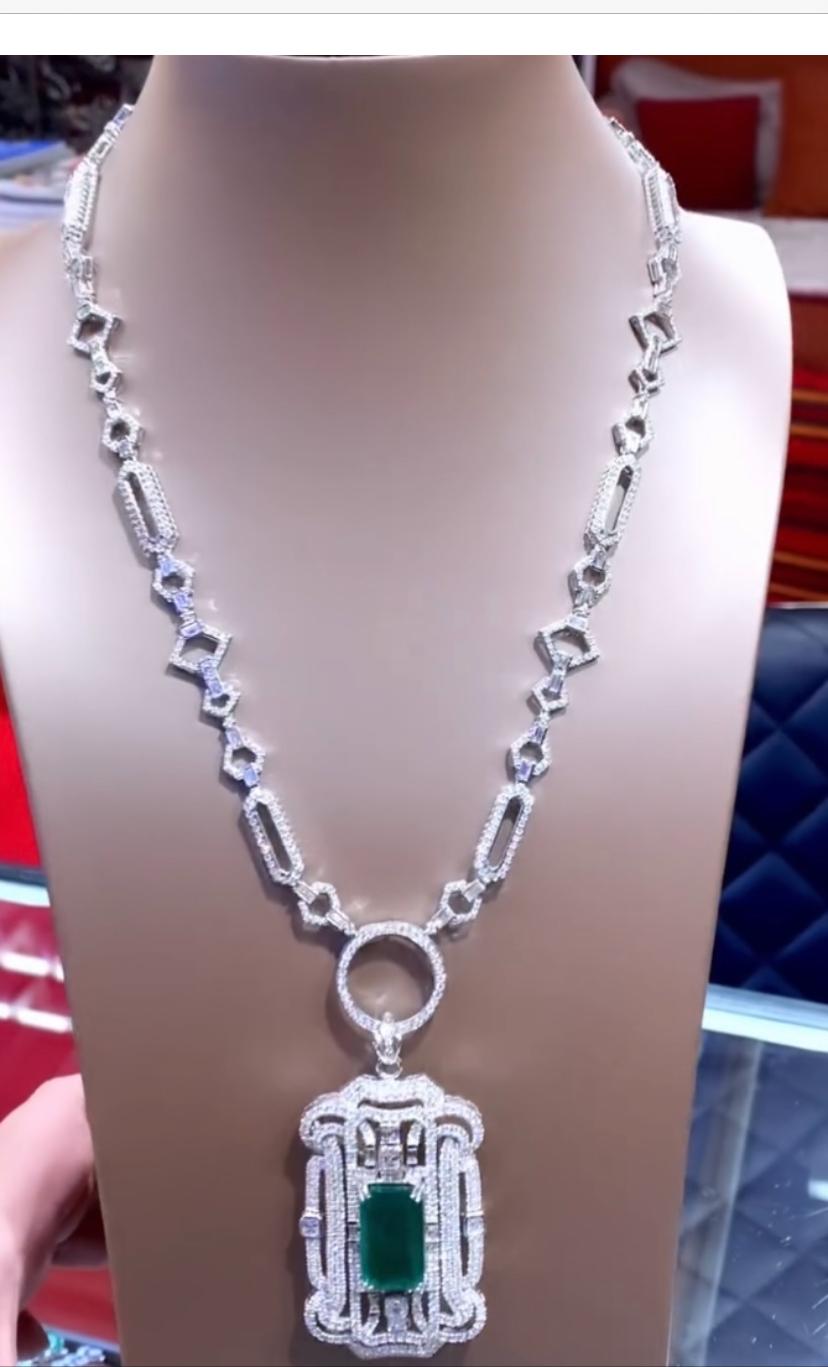 Diese exquisite Halskette im Art-Decò-Stil ist zusätzlich mit einem Anhänger aus leuchtenden sambischen Smaragden und Diamanten geschmückt, die dem ohnehin schon prächtigen Schmuckstück einen Hauch von Glamour und Raffinesse verleihen. Ein wahrer