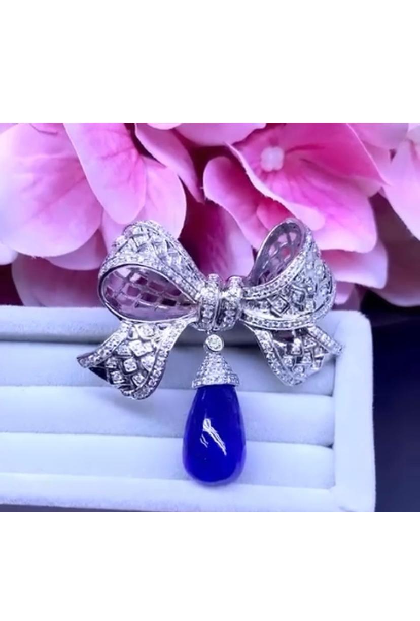 An exquisite Art Deco style for this beautiful brooch, so chic and elegant, in 18k gold with a natural tanzanite in cabochon cut, fine quality and particular color, of 21.24 carats, and 152 pieces of round brilliant cut diamonds of 1.76 carats,