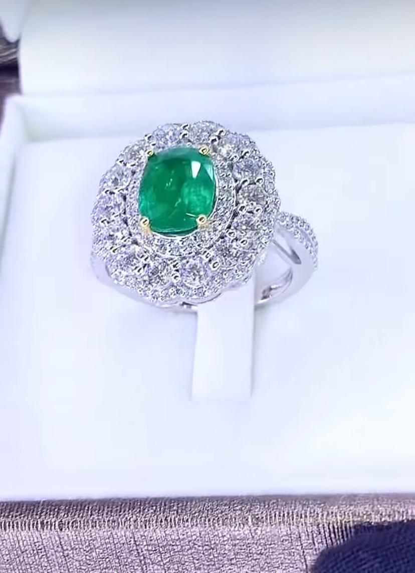 Dive into the allure of our 2,60 ct oval-shaped Natural Zambian Emerald, gracefully embraced by a halo of brilliant diamonds of 2,50 carats, F-G color VS clarity.Set in pristine 18k gold white, this ring is a fusion of vibrant green and sparkling