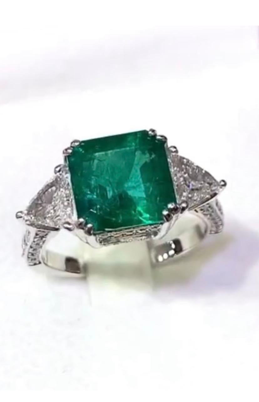 An exquisite contemporary design , so glamour and refined style. 
Ring come in 18k with a spectacular natural Zambia emerald, octagon cut, extra fine quality, ceo minor, 3,49 carats and two natural trillions cut diamonds, 0,40 carats each diamond x