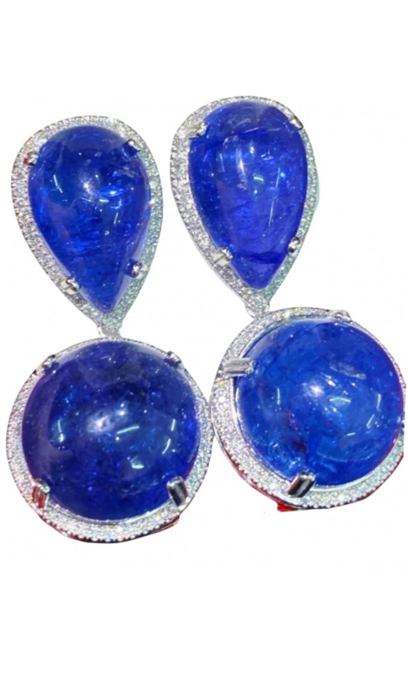 An exquisite pair of earrings in contemporary design, a very impressive and glamour style.
Earrings come in 18K gold with 4 pieces of Natural Tanzanites , in perfect cabochon cut ,fine quality, spectacular color, of 59 carats, so big, and natural