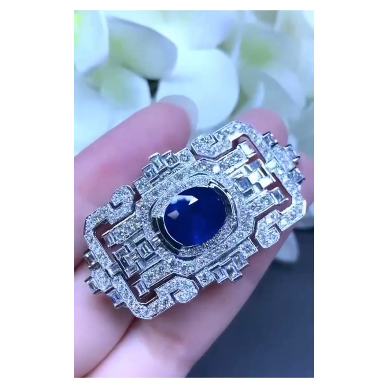 Eine exklusive Brosche/Anhänger im Art Deco Design, so elegant und raffiniert, ein echtes Kunstwerk.
Brosche/Anhänger aus 18-karätigem Gold mit einem natürlichen königsblauen Ceylon-Saphir mit perfektem Ovalschliff von 6,76 Karat und 148 funkelnden